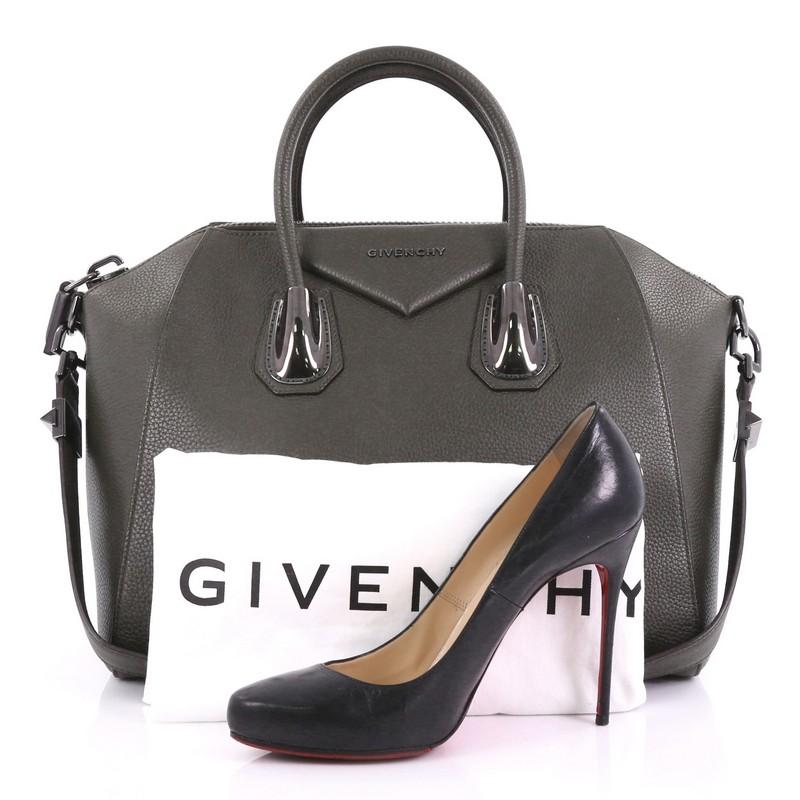 This Givenchy Antigona Bag Leather and Kenya Metal Medium, crafted from green leather, features Kenya metal detailing on its anchors, signature envelope flap detail with Givenchy logo, dual rolled leather handles, and gunmetal-tone hardware. Its zip