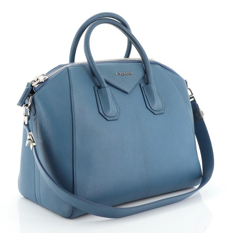 This Givenchy Antigona Bag Leather Medium, crafted from blue leather, features dual rolled leather handles and silver-tone hardware. Its zip-around closure opens to a neutral fabric interior with zip and slip pockets. 

Estimated Retail Price:
