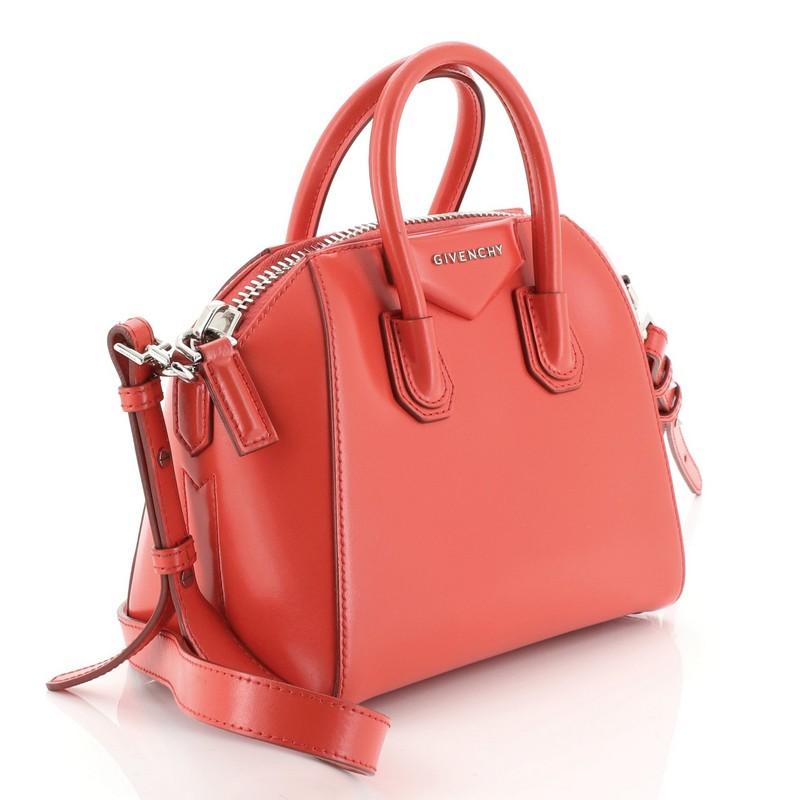This Givenchy Antigona Bag Leather Mini, crafted from red leather, features dual rolled leather handles and silver-tone hardware. Its zip closure opens to a black fabric interior with zip and slip pockets. 

Estimated Retail Price: $1,790
Condition: