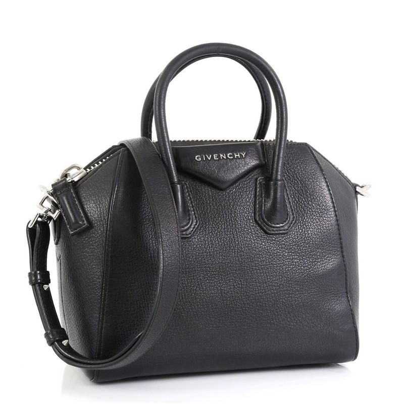 This Givenchy Antigona Bag Leather Mini, crafted from black leather, features dual rolled leather handles and silver-tone hardware. Its zip closure opens to a black fabric interior with zip and slip pockets.  

Condition: Fair. Scuffs and minor wear