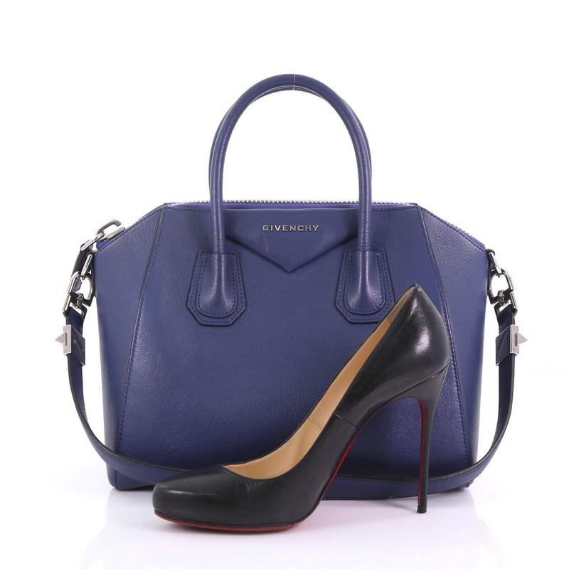 This Givenchy Antigona Bag Leather Small, crafted from blue leather, features dual top handles, and silver-tone hardware. Its top zip closure opens to a beige fabric interior with side zip and slip pockets. **Note: Shoe photographed is used as a