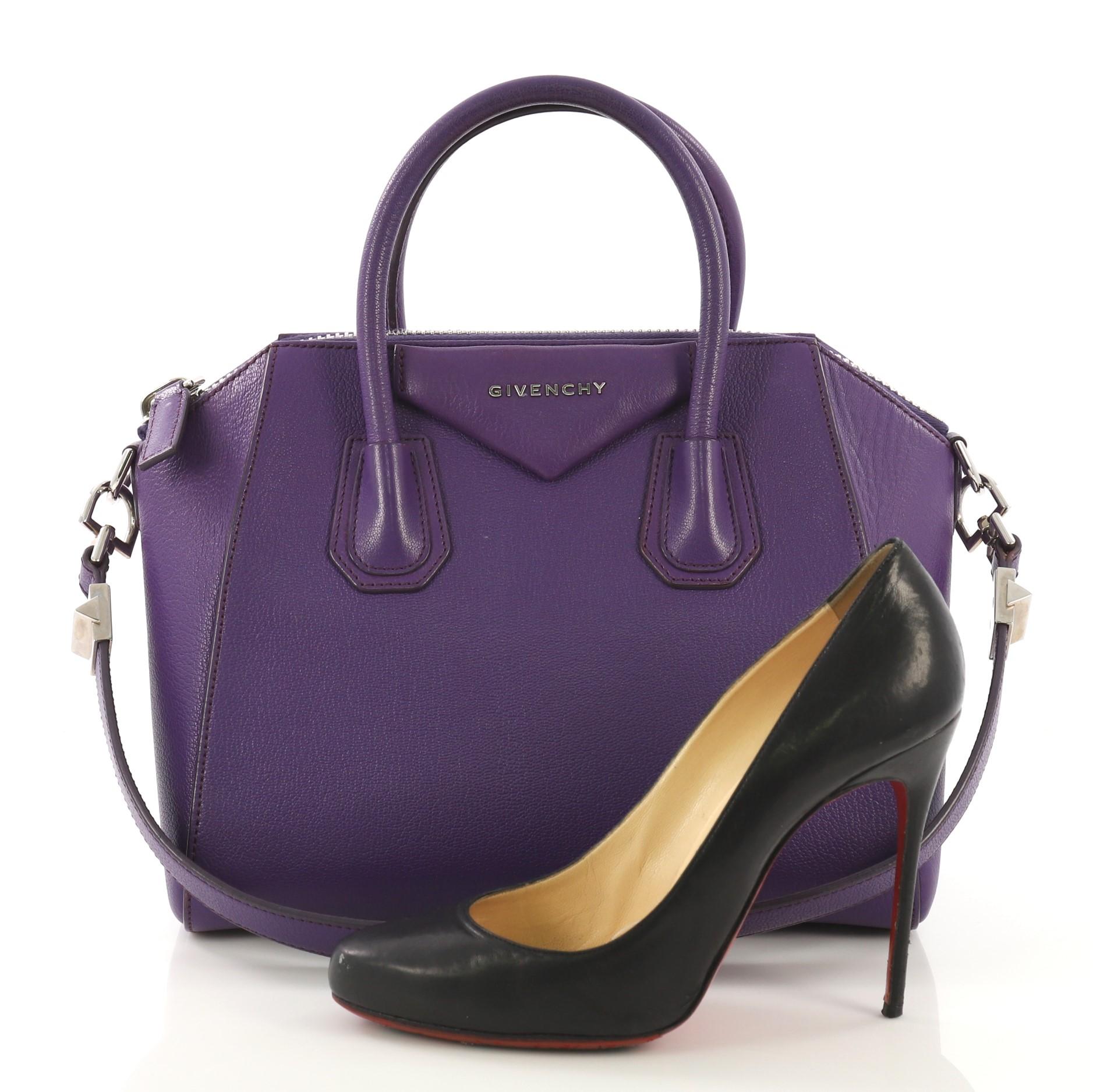 This Givenchy Antigona Bag Leather Small, crafted from purple leather, features dual rolled leather handles and silver-tone hardware. Its zip-around closure opens to a beige fabric interior with zip and slip pockets. **Note: Shoe photographed is