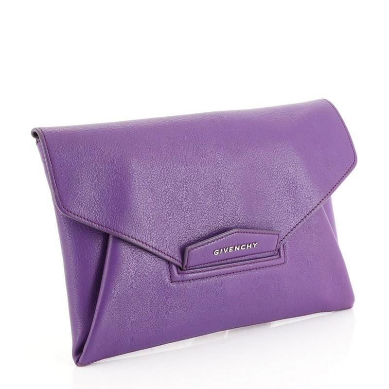 This Givenchy Antigona Envelope Clutch Leather Medium, crafted in purple leather, features an envelope flap top with raised Givenchy logo, magnetic flap that tucks into slot, and silver-tone hardware. Its flap opens to a neutral fabric interior