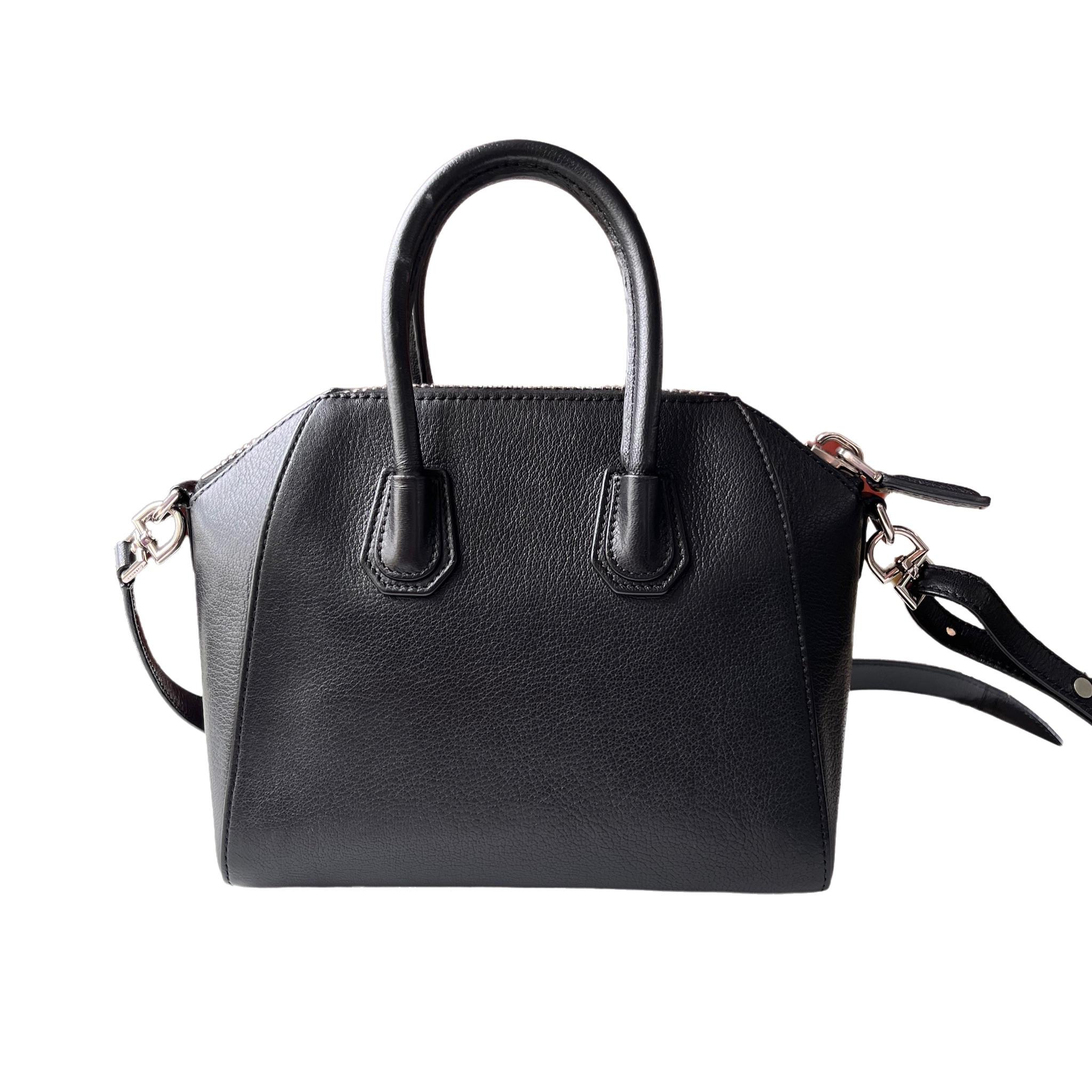 This iconic design boasts a roomy interior, perfect for carrying all your essentials. Crafted with high-quality and durable black leather. It features two top handles and a long removable shoulder strap, making it versatile and practical for any