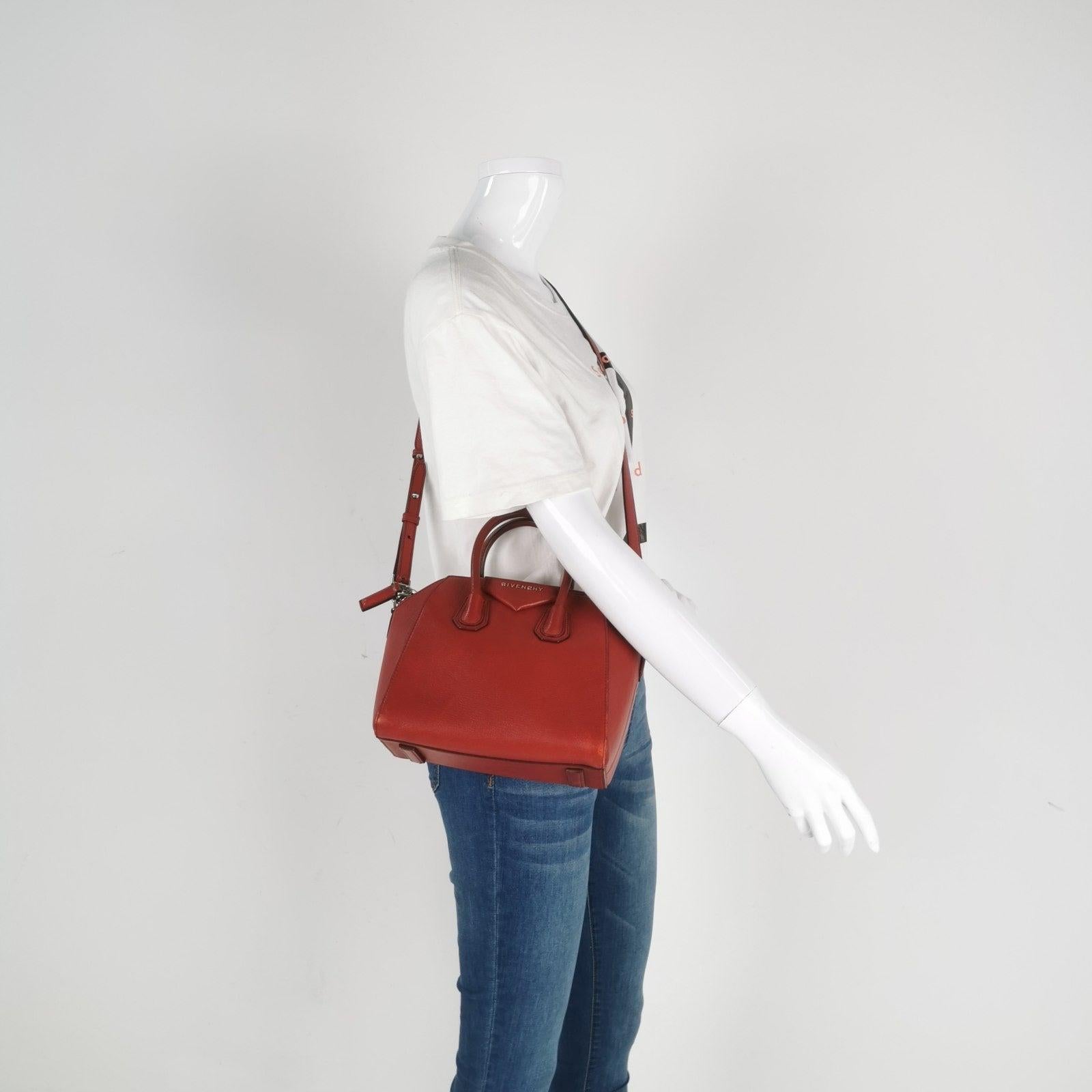 Givenchy Antigona Mini Red Calf Leather Top Handle bag with Strap These are professional photos of the actual bag offered by Luxbags. This iconic design boasts a roomy interior, perfect for carrying all your essentials. Crafted with high-quality and