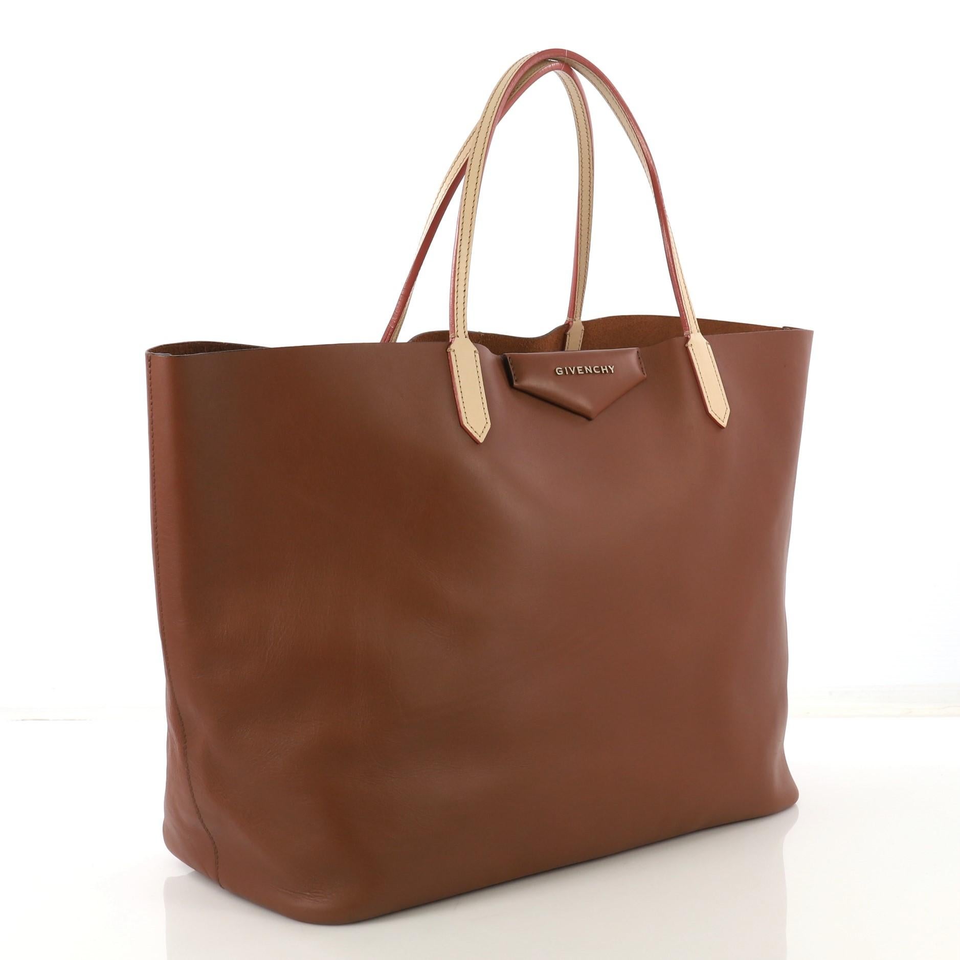 This Givenchy Antigona Shopper Leather Large, crafted in brown leather, features raised envelope fold logo, dual leather slim handles, and gold-tone hardware. Its wide open top opens to a brown raw leather interior. 

Estimated Retail Price: