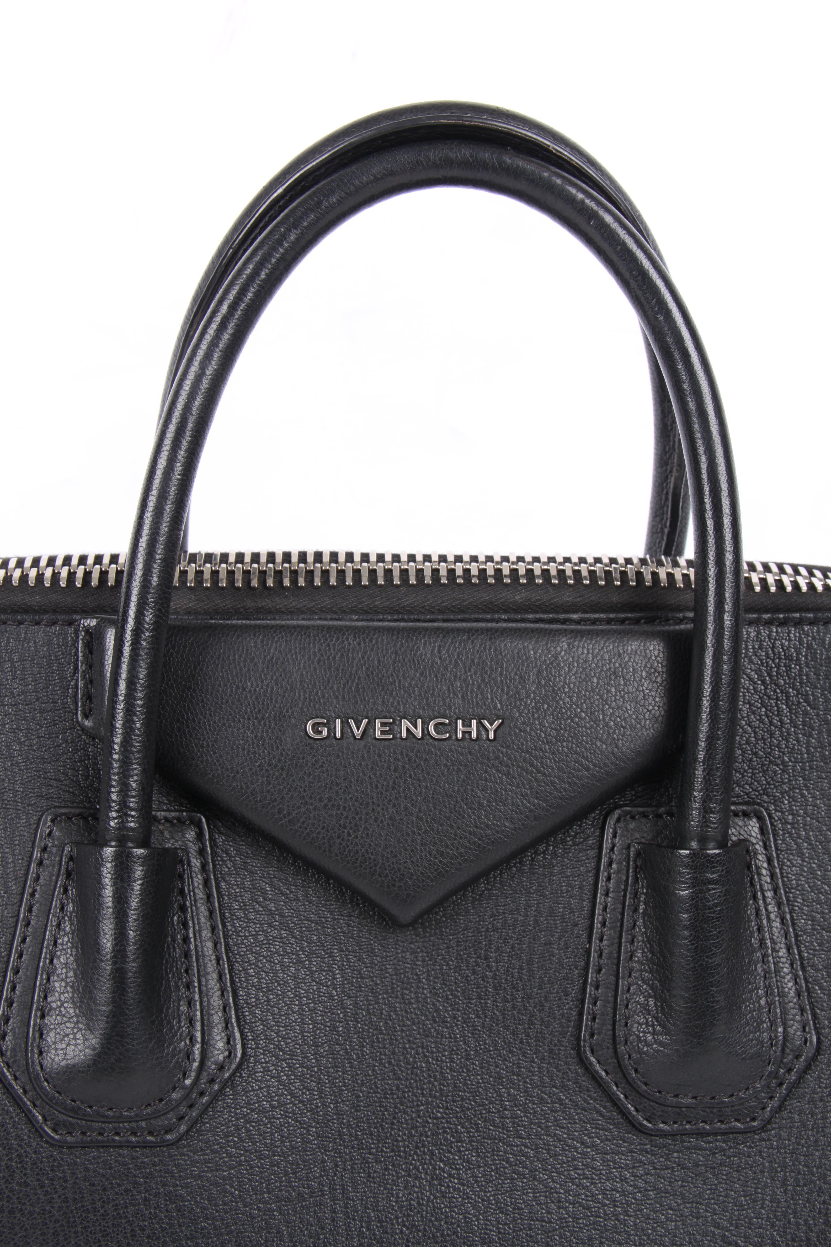 Wonderful basic bag designed by Givenchy wearing the name Antigona, this is size medium.

A trapezoid-shaped model. Crafted from sturdy black leather with silver-tone hardware. Two handles on top and a shoulder strap.

Top closure with a zipper,