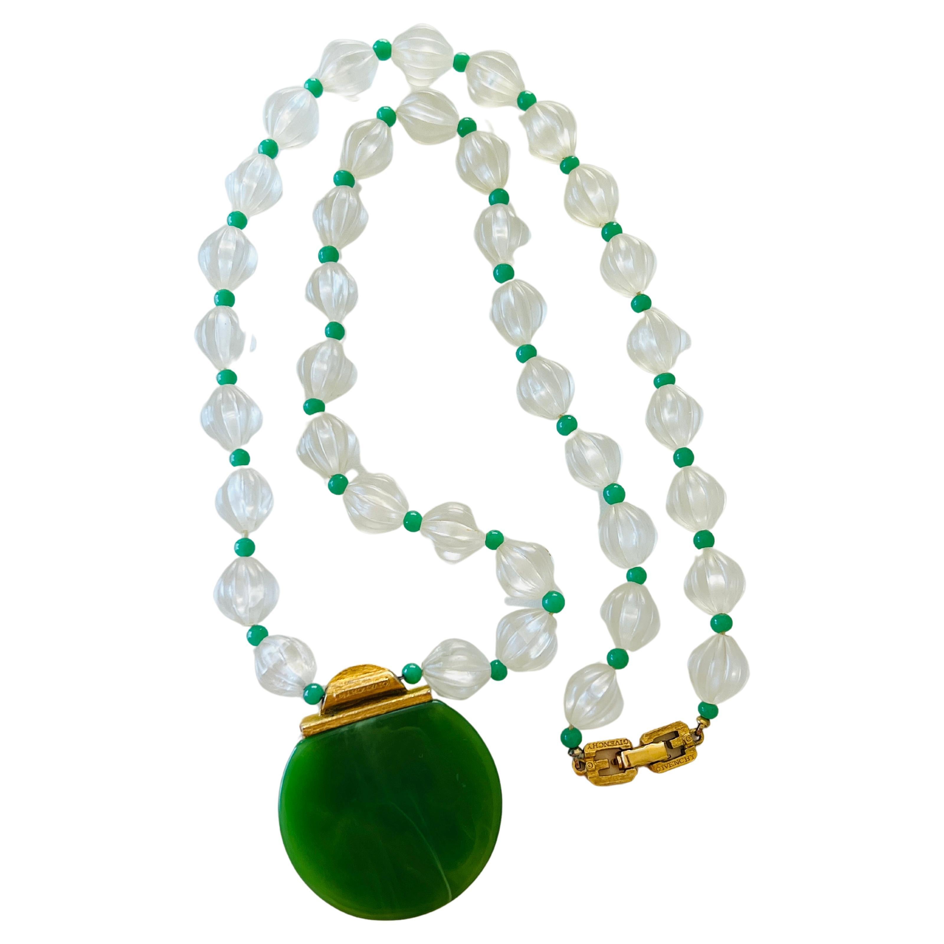 Step into the elegance of the 1980s with this exquisite Art Deco style necklace by Givenchy. This stunning piece features a captivating pendant crafted from imitation jade Lucite, adorned with black enamel and dazzling clear pave rhinestones. The