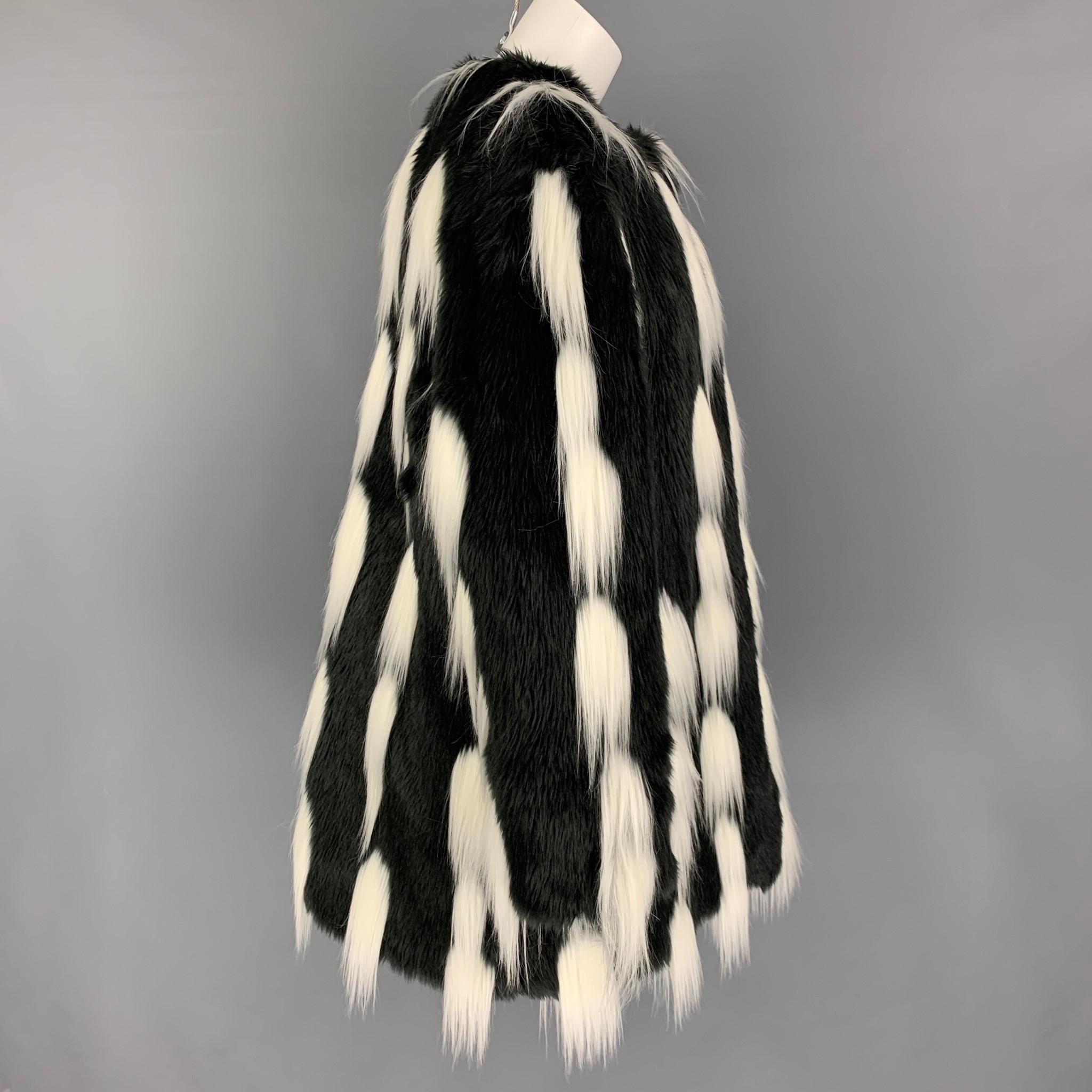 GIVENCHY AW 19 coat by Clare Waight Keller comes in a black & white monochrome animal print faux fur with a silk lining featuring a oversized fit, high neck, long sleeves, and a hook & loop closure. t’s cut to an oversized fit with a high neck and
