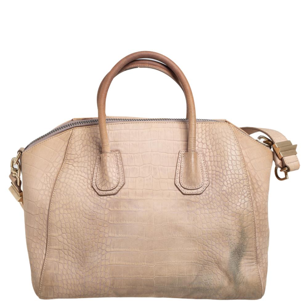 Made in Italy, and loved by women worldwide is this beautiful Antigona satchel by Givenchy. It has been crafted from croc-embossed leather and carries an elegant shape. The beige bag has a top zipper that reveals a fabric interior whilst being held