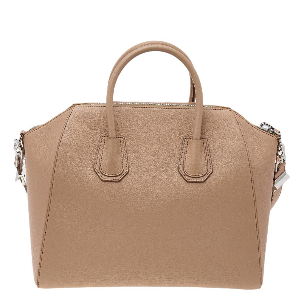 Made in Italy, and loved by women worldwide is this beautiful Antigona satchel by Givenchy. It has been crafted from leather and shaped elegantly. The beige bag has a top zipper that reveals a canvas interior and it is held by two top handles and a