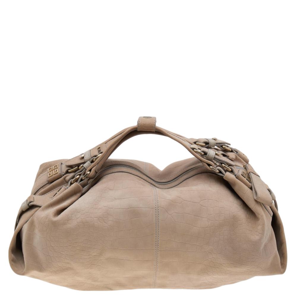 Add a luxurious touch to your collection of accessories with this Givenchy hobo. It is made from embossed leather. It comes in an understated beige hue. It is styled with short handles, fabric interior, and enough space for essentials. It is