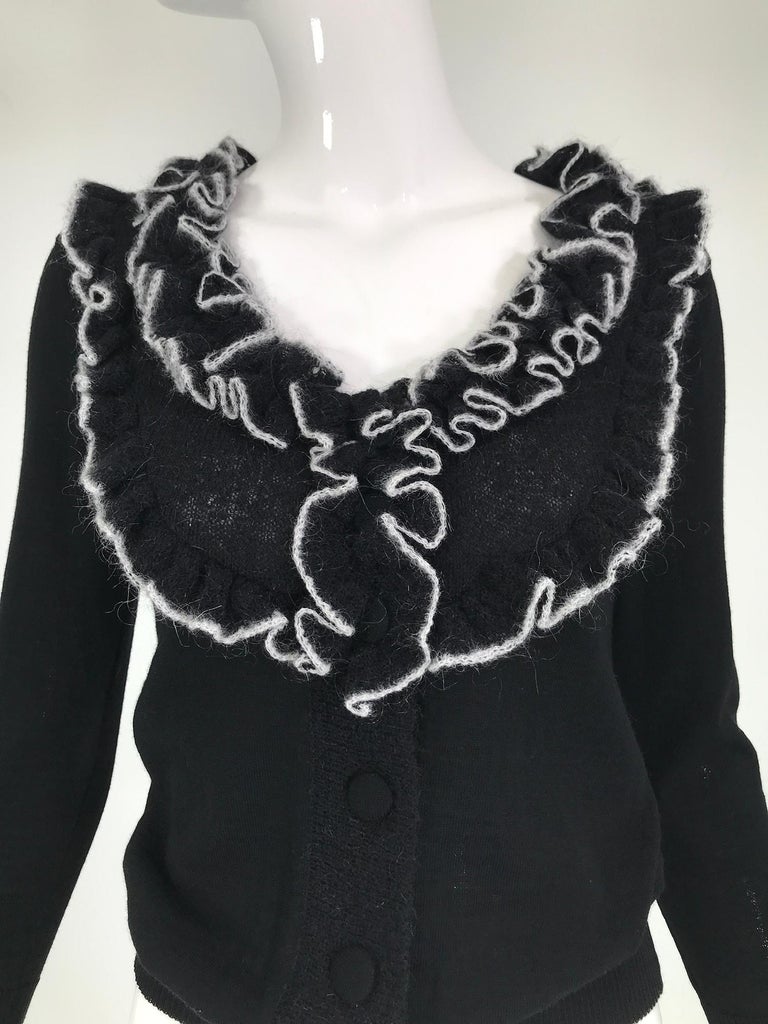 Givenchy black fine wool knit with white angora trim on the  wide ruffle collar. Faux buttons at the front, ribbed hem & cuffs. Pull on style. Marked size medium.
 In excellent wearable condition.  All our clothing is dry cleaned and inspected for