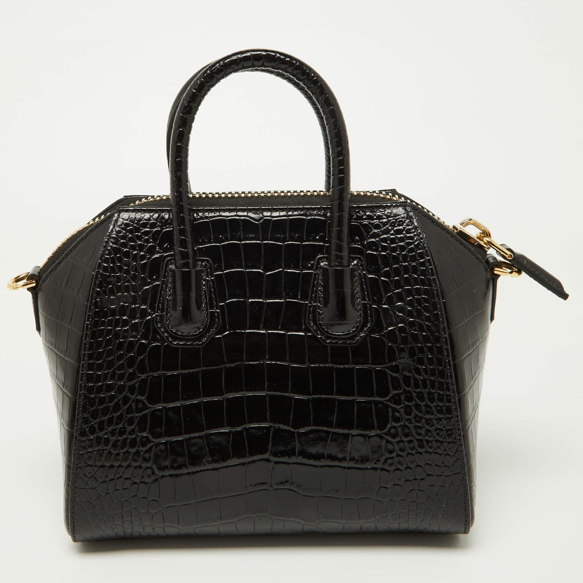 Made in Italy, and loved by women worldwide is this beautiful Antigona satchel by Givenchy. It has been crafted from croc-embossed leather and shaped elegantly. The black bag has a top zipper that reveals a canvas interior and it is held by two top