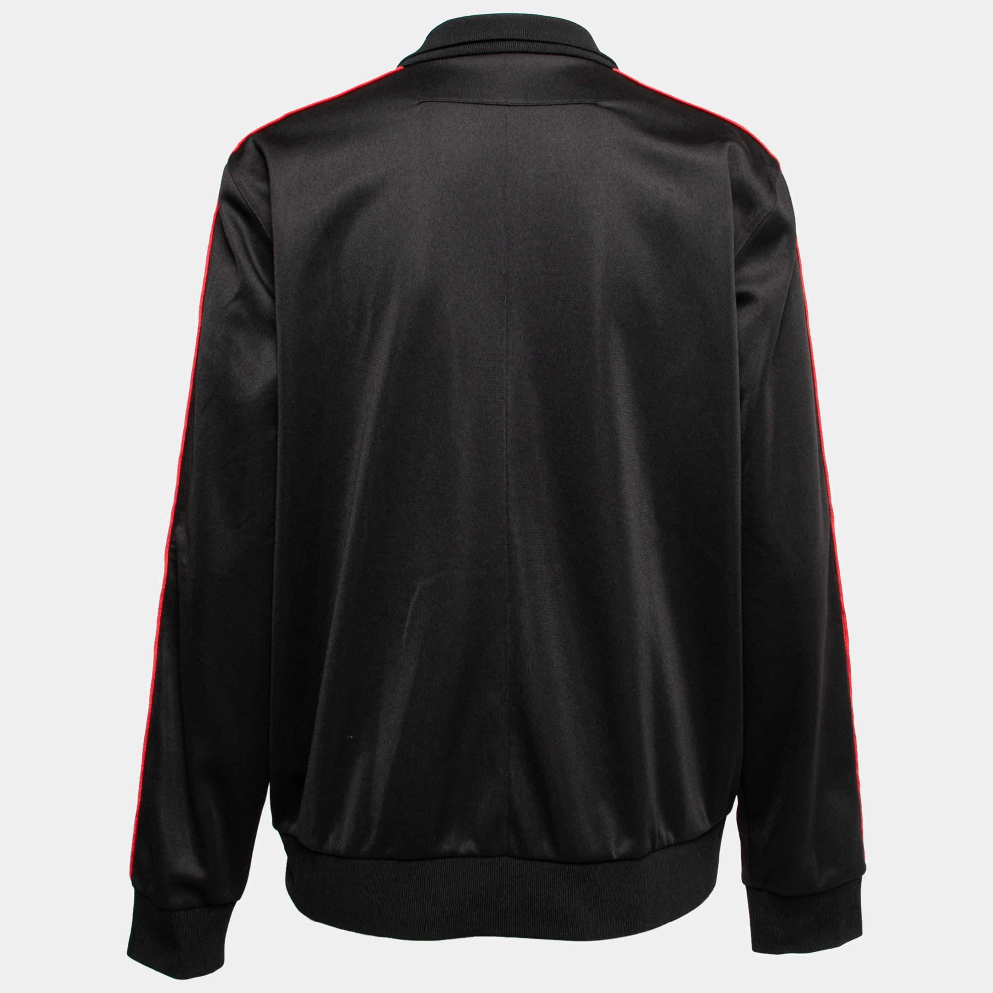 Sfoggia un look elegante e senza sforzo con questa giacca della Maison Givenchy. È realizzato su misura in tessuto jersey nero, con bordi in nastro logato che evidenziano le maniche lunghe. Questa giacca ha una chiusura frontale con zip, un colletto