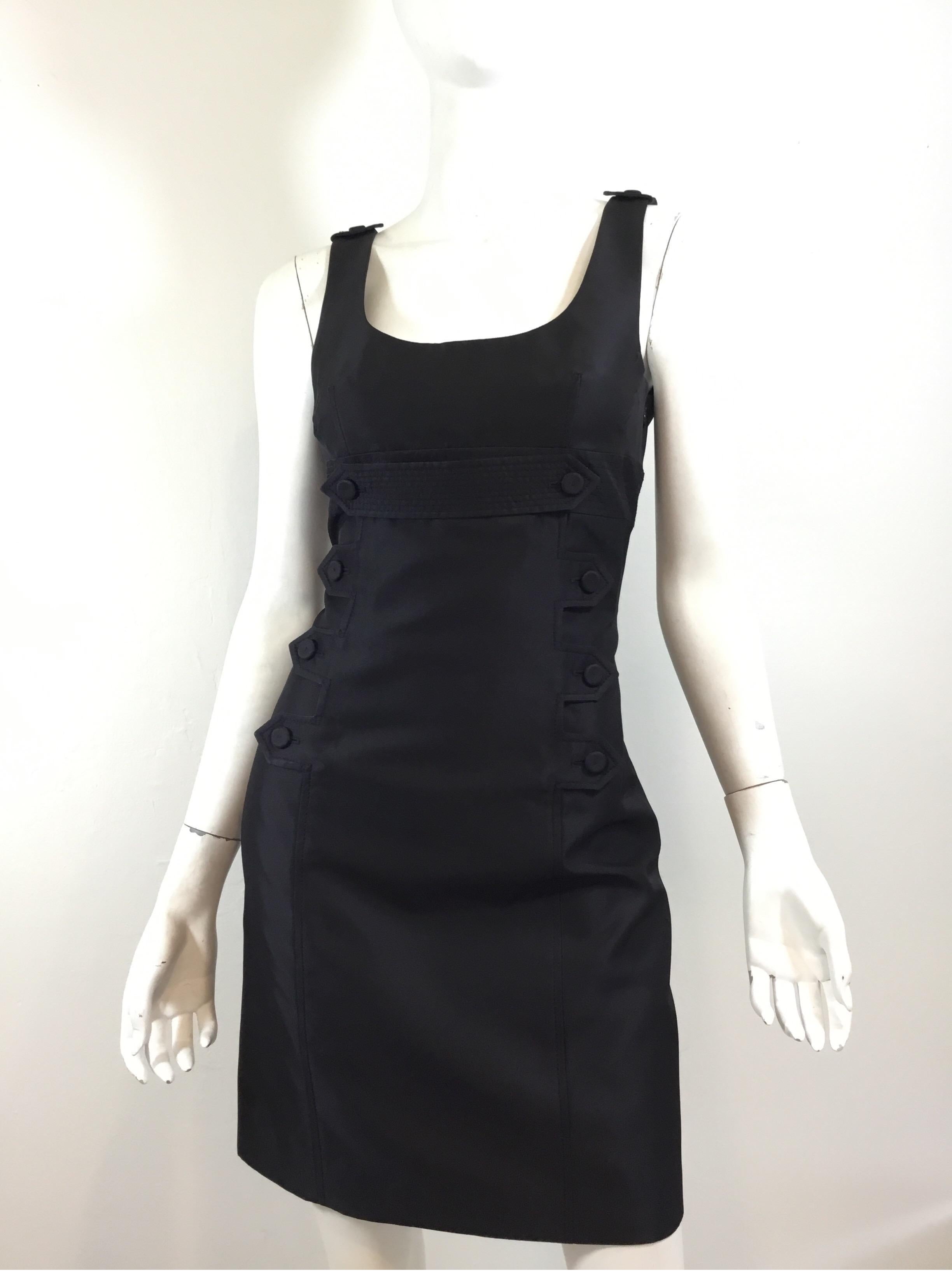 Givenchy Dress featured in a black with decorative buttons along the front. Dress has a side zipper fastening and full lining. Size 38, made in France. 

Bust 33”, waist 30”, hips 34”, length 32”