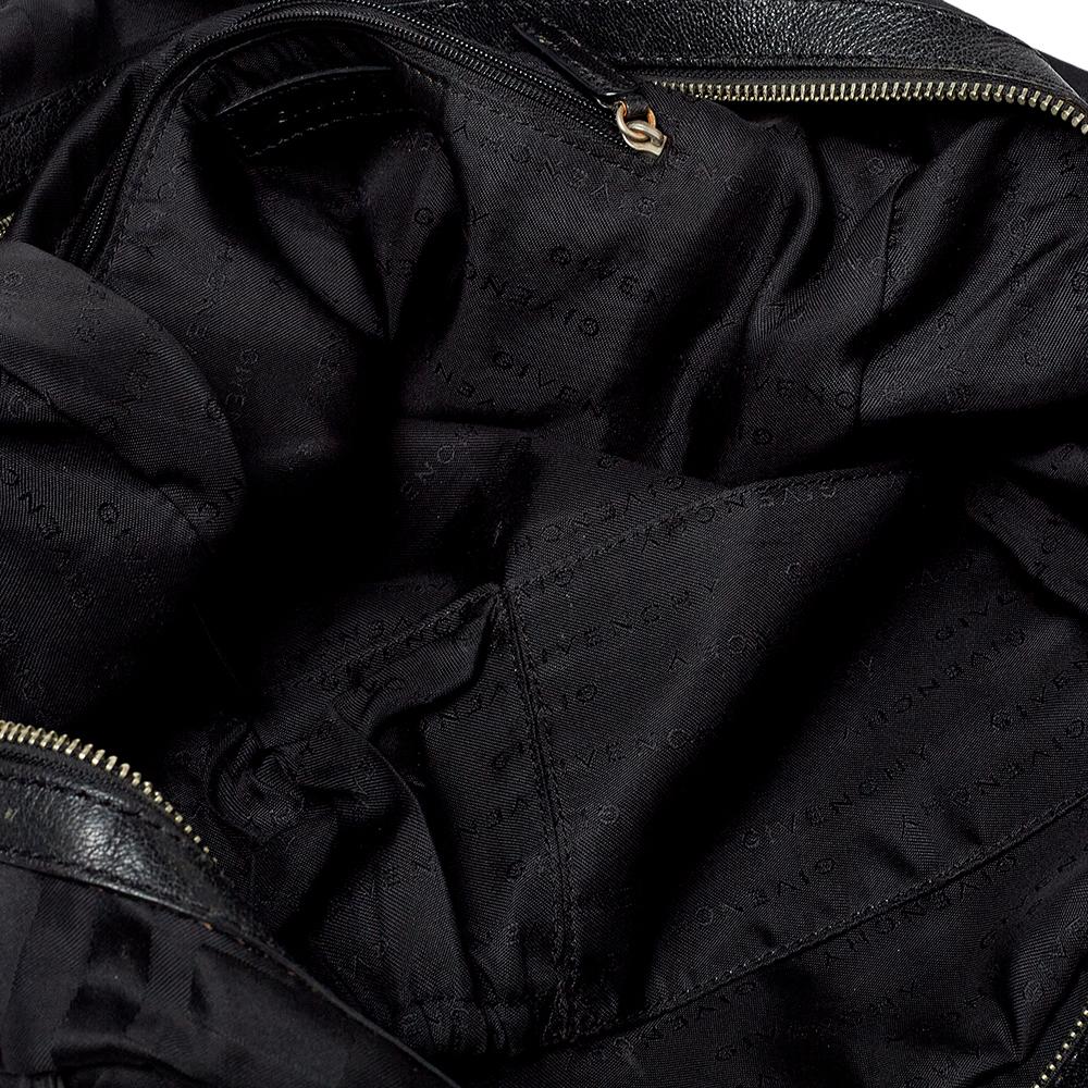 Spacieux et captivant, ce sac polochon est signé Givenchy. Il a été fabriqué à partir de la toile et du cuir emblématiques de la marque, avec des accessoires en métal argenté. Il est équipé d'un intérieur en tissu bien dimensionné et de deux