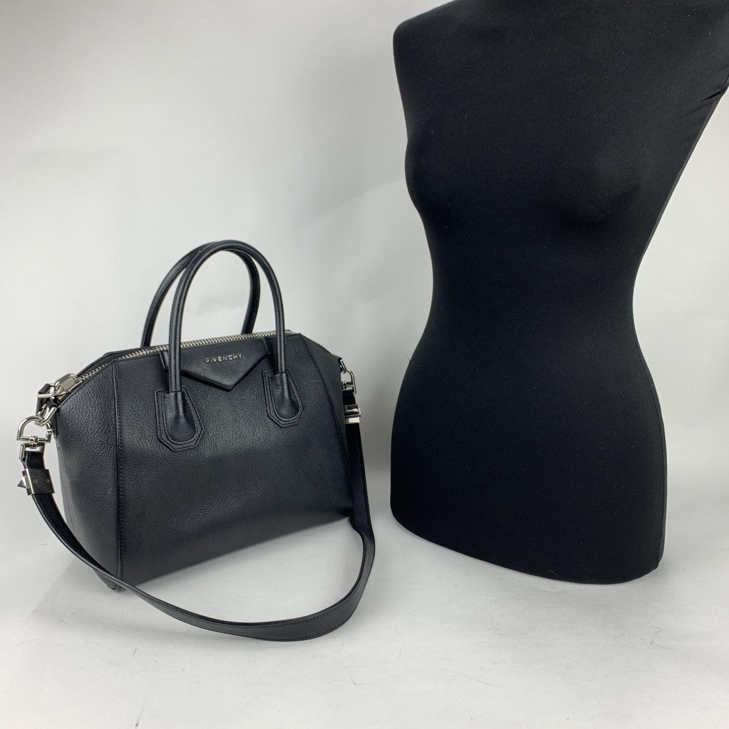 Beautiful black leather GIVENCHY Small 'Antigona' bag. It features envelope flap detail with logo lettering, silver metal hardware, upper zipper closure, structured base, double handles and a removable shoulder strap. Lined with black textile