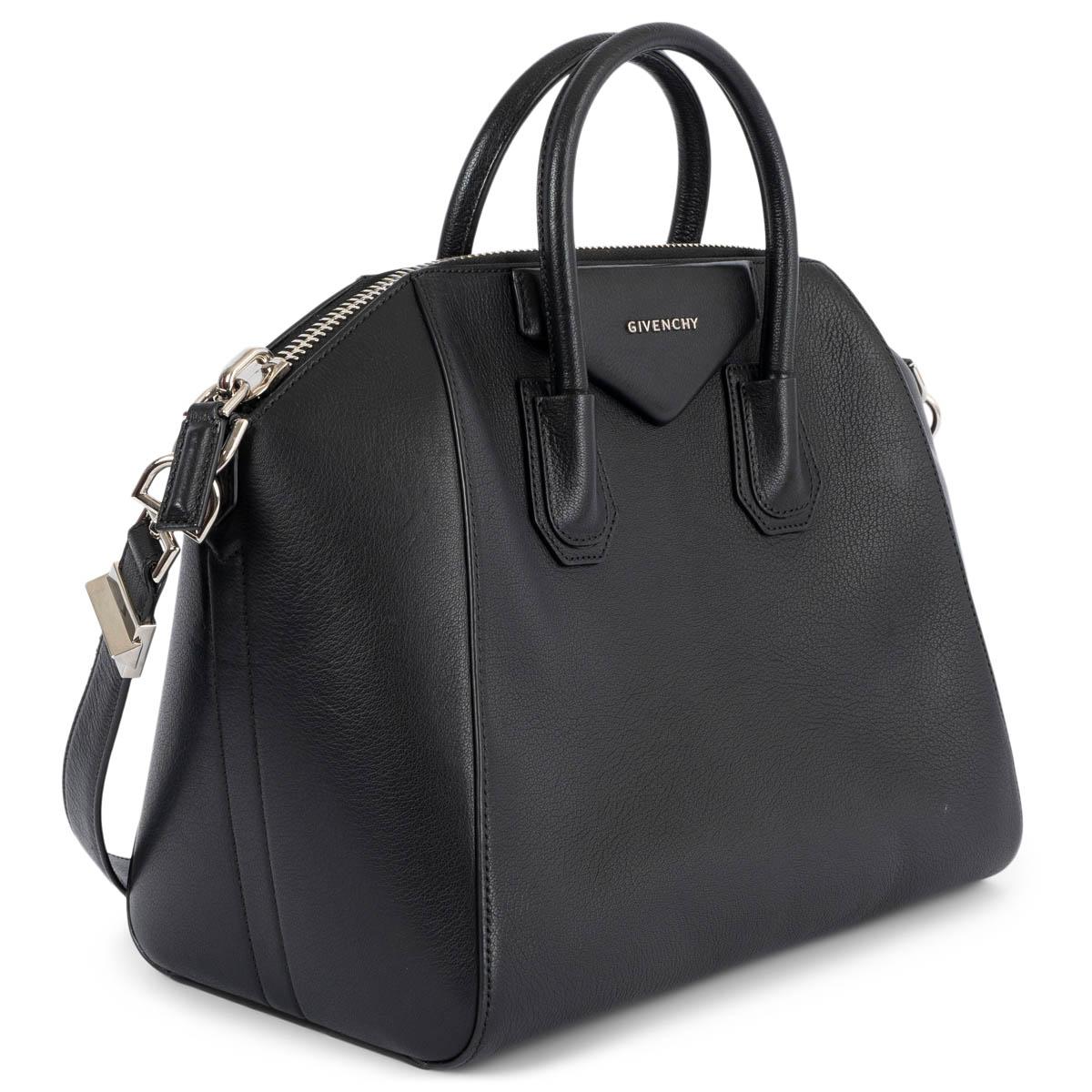 100% authentic Givenchy Antigona Medium duffle bag in black goatskin. Opens with a oversized silver-tone zipper on top and is lined in black canvas with one zipper pocket against the back and two open pockets against the front. Has been carried and