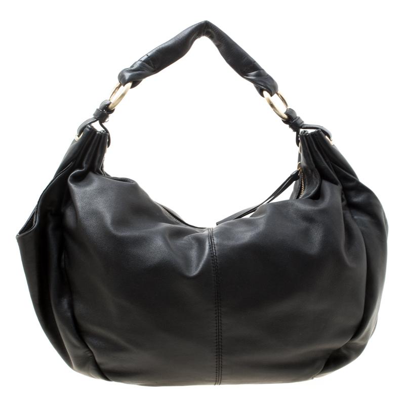 Meticulously crafted from black leather, this Givenchy hobo exudes the right amount of elegance. The bag features a single handle and a top zipper that opens to a spacious fabric-lined interior housing a zip pocket. Flaunt a trendy and modern look