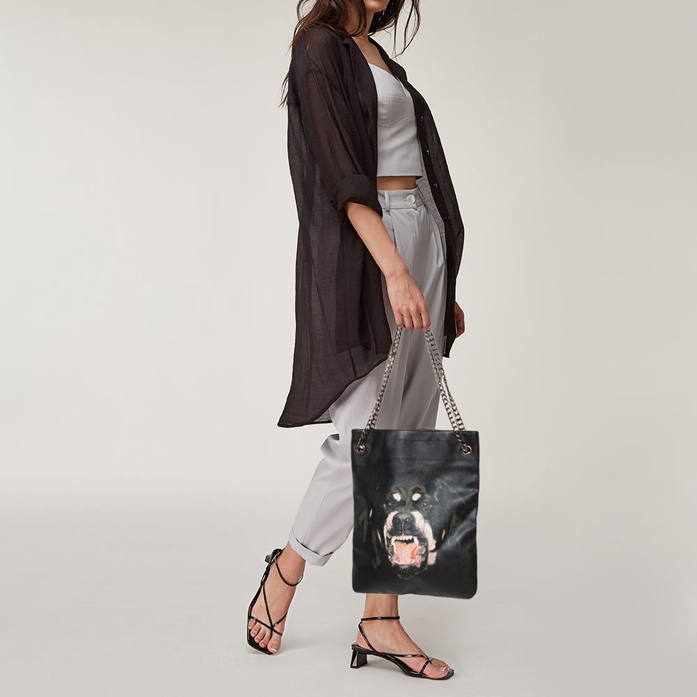 Givenchy's distinctive sensibilities come alive in this tote bag. Crafted from leather, it features a growling Rottweiler's face atop a black background. The creation is generously spaced and complete with chain handles.

Includes: Original Dustbag,