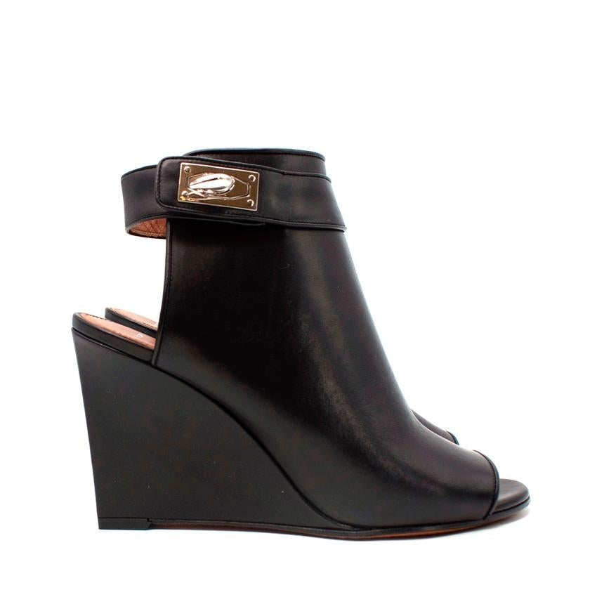 Givenchy Black Leather Silver Shark Tooth Wedge Heeled Booties
 

 - Black smooth leather peep toe booties, with cut-out heel and narrow ankle strap featuring the signature shark's tooth lock
 - Leather wrapped wedge heel 
 

 Materials 
 100%