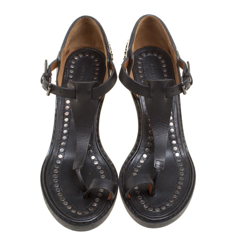 Your search for something unique and different ends with this fabulous pair from Givenchy. These black sandals are crafted from leather and feature a toe ring and a T-strap silhouette. They flaunt buckled ankle straps, comfortable leather lined