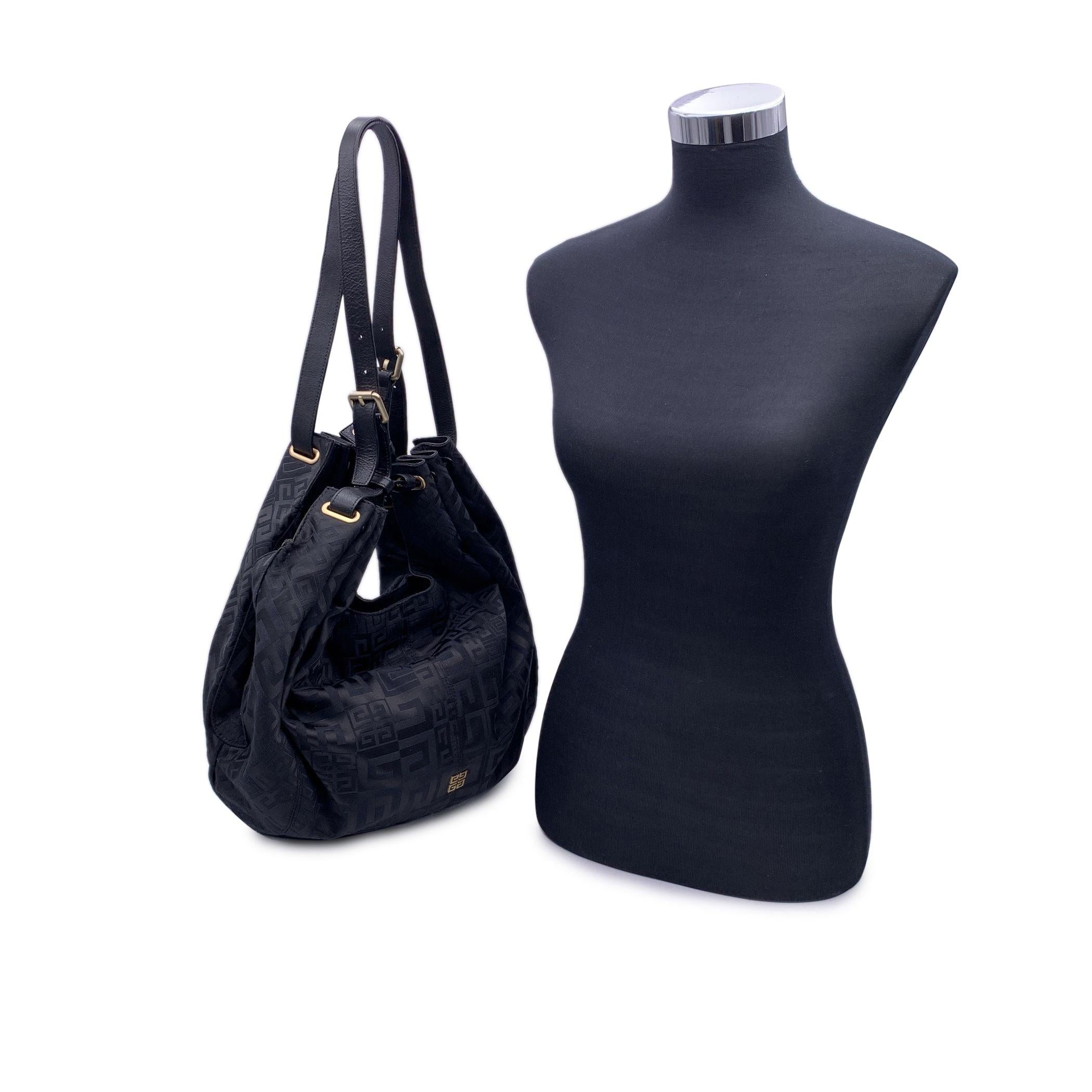Beautiful Givenchy tote bag in black logo canvas with black leather trim and handles. Leather shoulder straps. Magnetic button closure on top. Black fabric lining. 1 side zip pocket inside. 'Givenchy' tag inside. Imported. Condition B - VERY GOOD