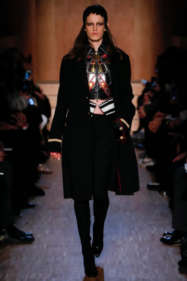 Givenchy - Cappotto nero di media lunghezza con spacchi laterali. Fondo delle maniche in velluto rosso bordato con trecce dorate. Bottoni in metallo dorato. Non è indicata la taglia, si adatta a una S.I.M. Collezione Autunno-Inverno 2016, sotto la