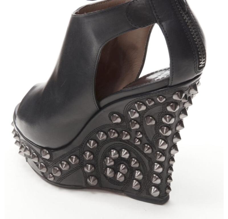 GIVENCHY nero argento spike barocco con zeppa gladiatore EU36.5
Riferimento: ANWU/A00985
Marchio: Givenchy
Designer: Riccardo Tisci
Materiale: Pelle
Colore: Nero, Silver
Modello: Tinta unita
Chiusura: zip
Fodera:  Pelle
Dettagli extra: Cinturino