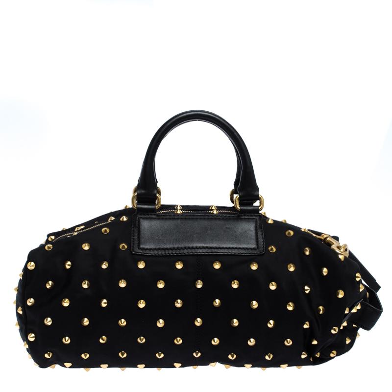 A bag with spacious interior and a stylish modern design, this Givenchy satchel is easy to wear with your casual as well as stylish evening looks. Crafted in black nylon fabric, this beautiful bag is enhanced with gold studs all over the surface of