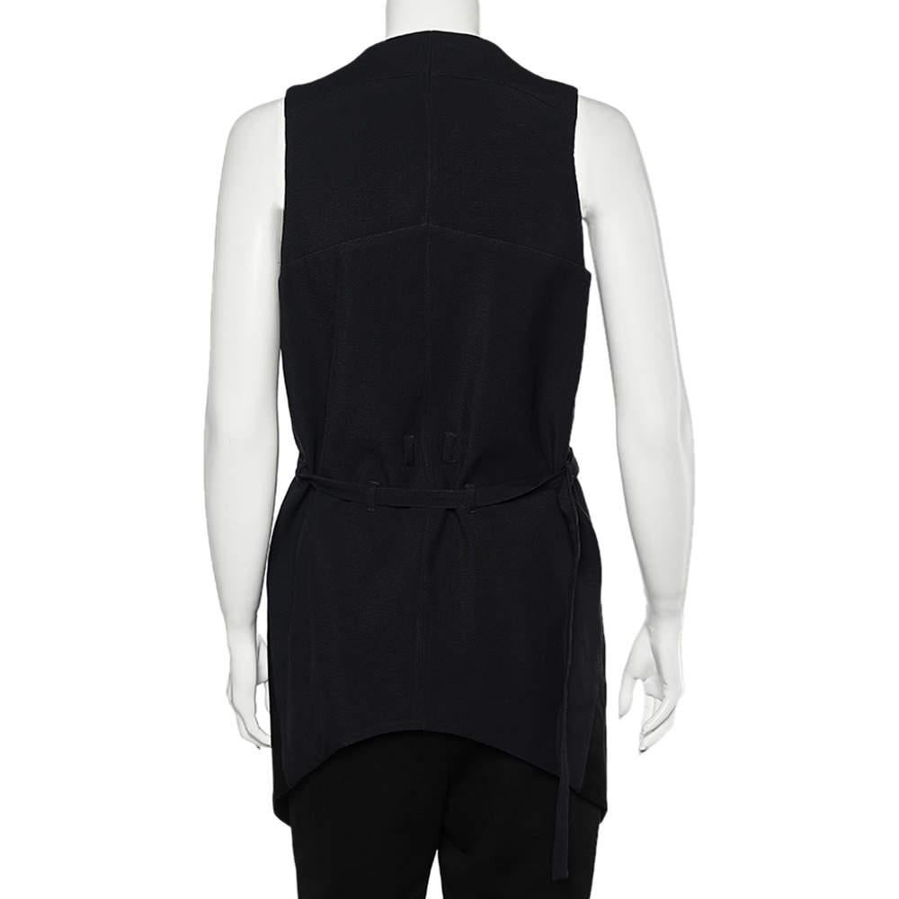 Givenchy's creations will forever help you appear classy and charming. This vest from Givenchy is tailored using black two-toned sateen fabric with a belted detail enhancing its beauty. It flaunts an asymmetric hemline and buttoned closure. Wear