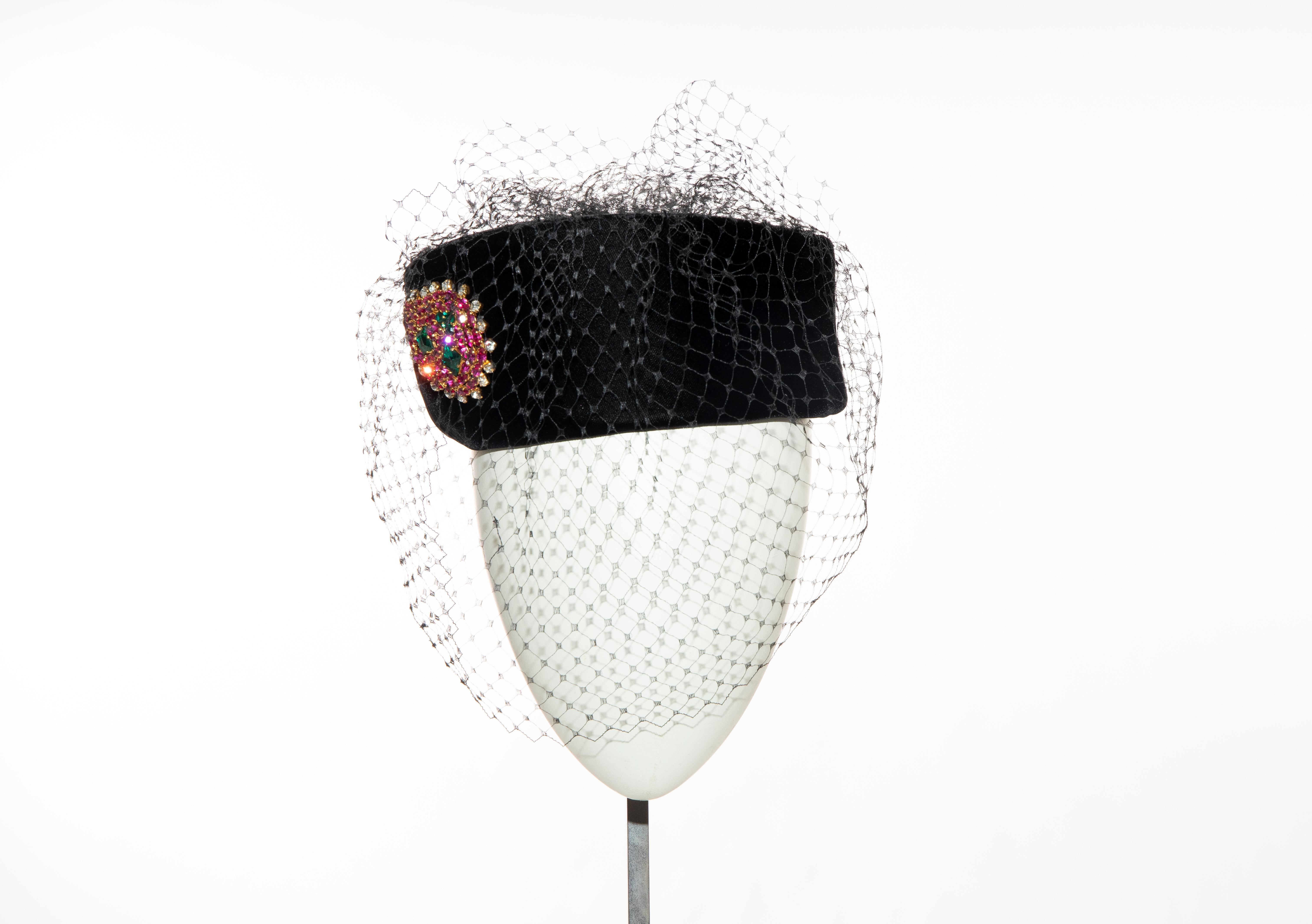 Givenchy, Circa: 1980's black velvet pill box hat with prong-set crystal brooch and black birdcage veil.

Comes with original Givenchy hat box.

Circumference: 24