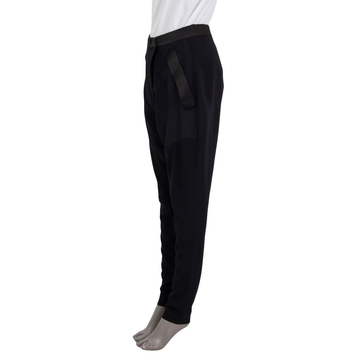 100% authentique Pantalon de jodhpur d'inspiration équestre Givenchy en viscose (95%) et élasthanne (5%) noirs avec détails en satin noir en soie (100%). Ce modèle comporte deux poches fendues sur le côté, des fermetures éclair aux poignets, une