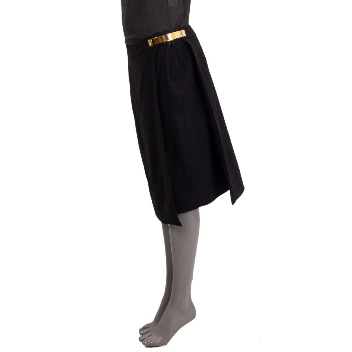 100% authentic Givenchy paneled pencil skirt in black viscose (96%) elastane (4%) with two golden metal parts at the waist and two overlap in the front and back. Closes with concealed zipper at the left side. Lined in black viscose (100%). Has been