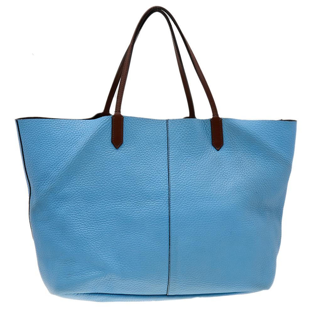 This large Antigona shopper tote by Givenchy is loved by shopaholics. Crafted from leather and accentuated with a blue shade, this Antigona bag displays craftsmanship at its best. Top handles and a front logo plaque complete it. Take yours to both