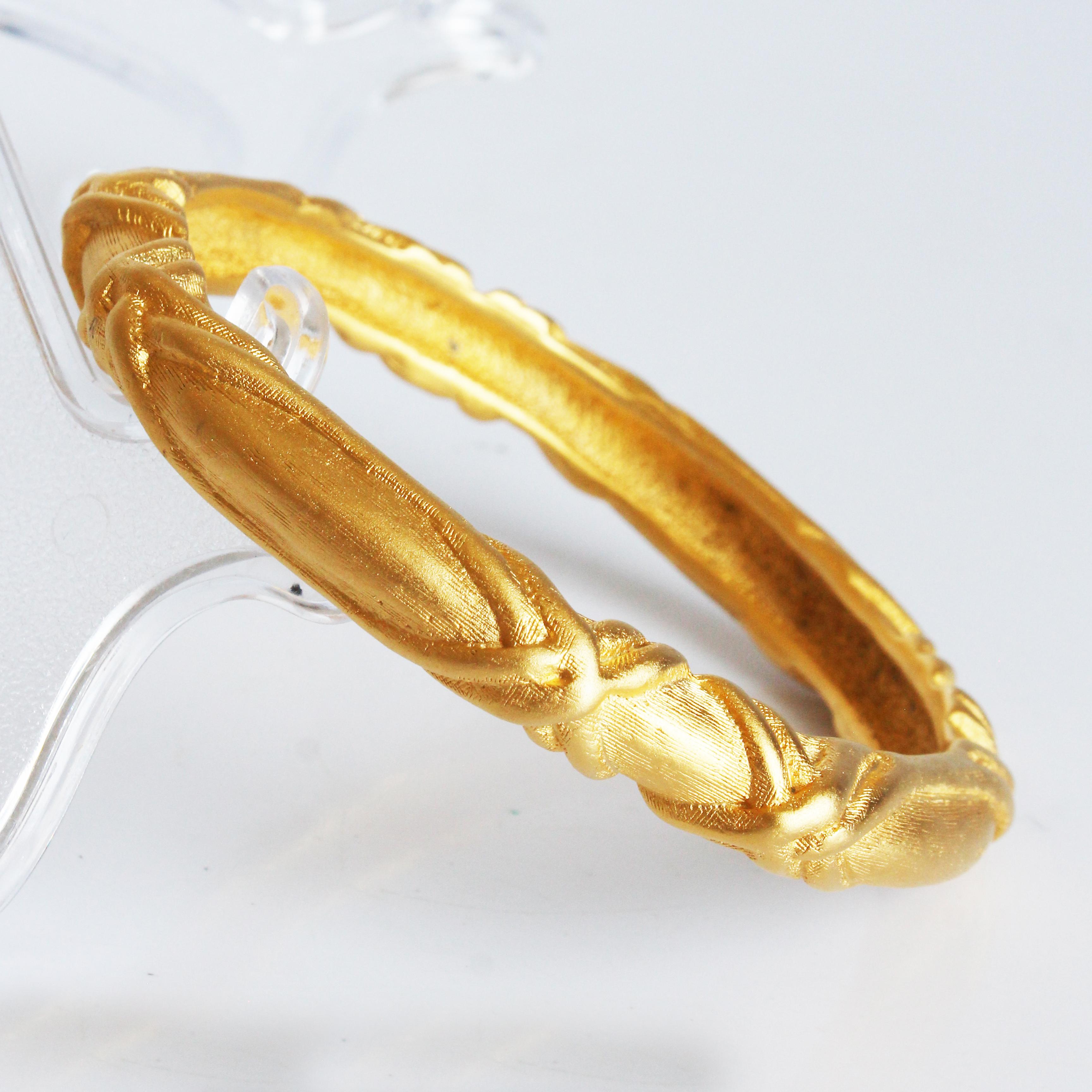 Bracelet vintage Givenchy d'occasion, probablement fabriqué dans les années 80.  Réalisé en métal doré, ce bracelet est orné d'un motif abstrait en forme de croix.  

Il est magnifique tel quel - ou associé à vos autres bracelets préférés ! La
