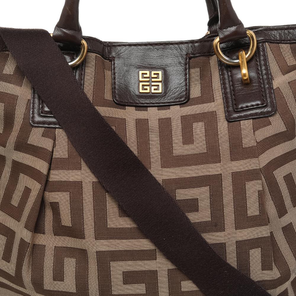 This Givenchy hobo is made from canvas with the signature print all over. Brown leather trims adds graceful, clean lines to this design. It is equipped with dual handles & a long strap, and a zip fastening secures it at the top. The fully lined