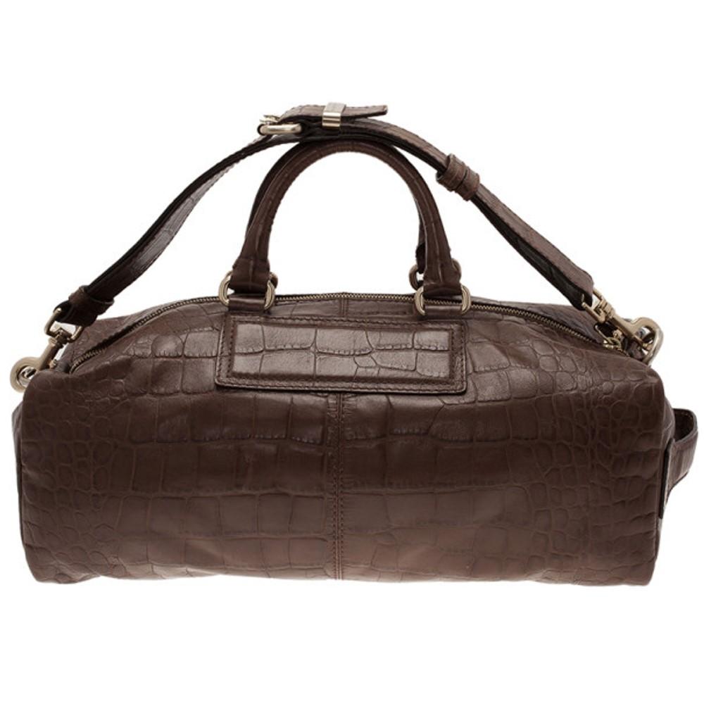 This downtown chic duffle bag by Givenchy will comfortably hold all your daily necessities. Crafted from croc embossed leather, it is finished with gold-tone hardware, a Givenchy logo, a removeable shoulder strap and rolled leather handles. The