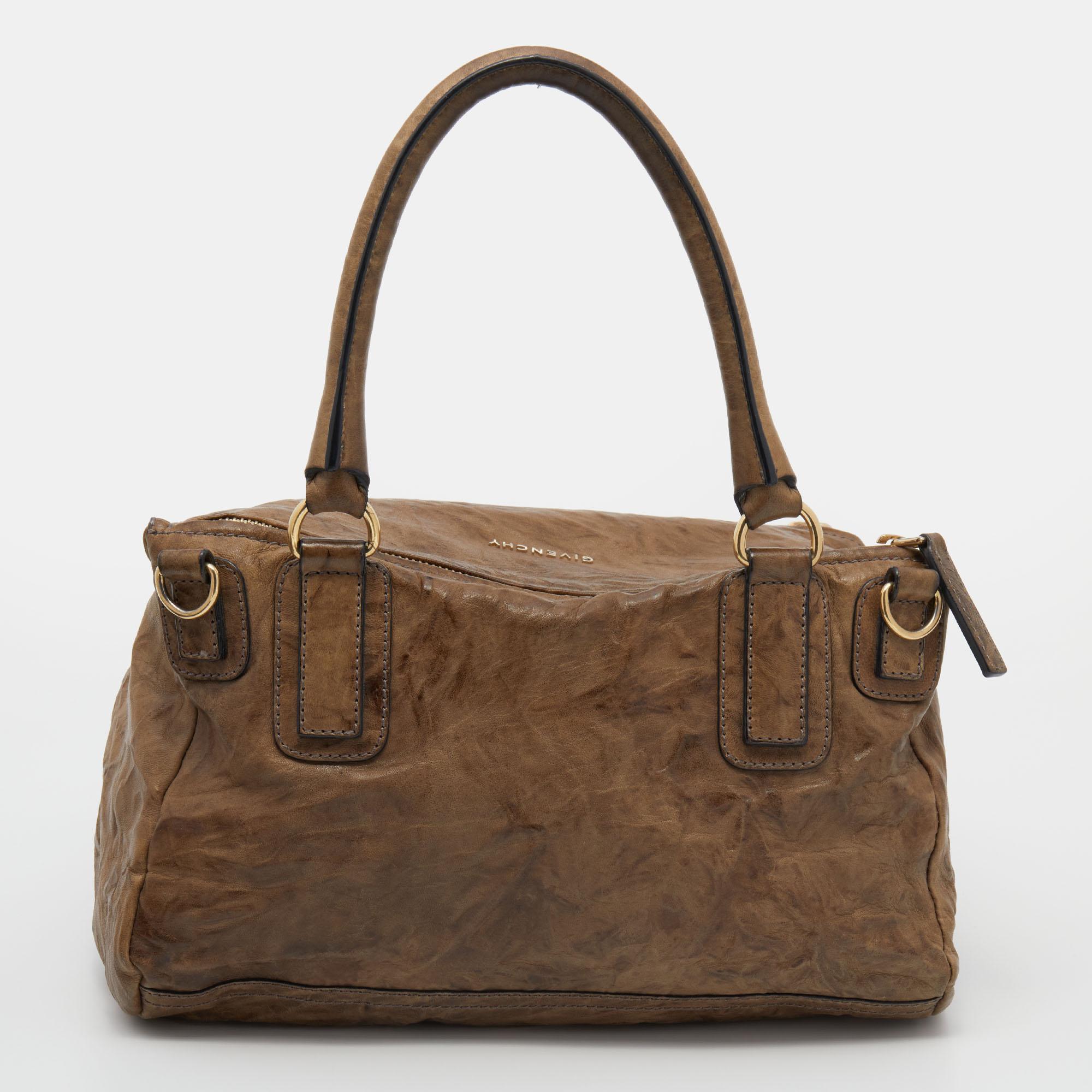 Durably fashionable, this Givenchy Pandora bag will prove to be an all-season favorite. This beautifully made bag has gold-tone metal additions, two different handles, and a front zip pocket. The fabric-lined interior is perfectly sized to house