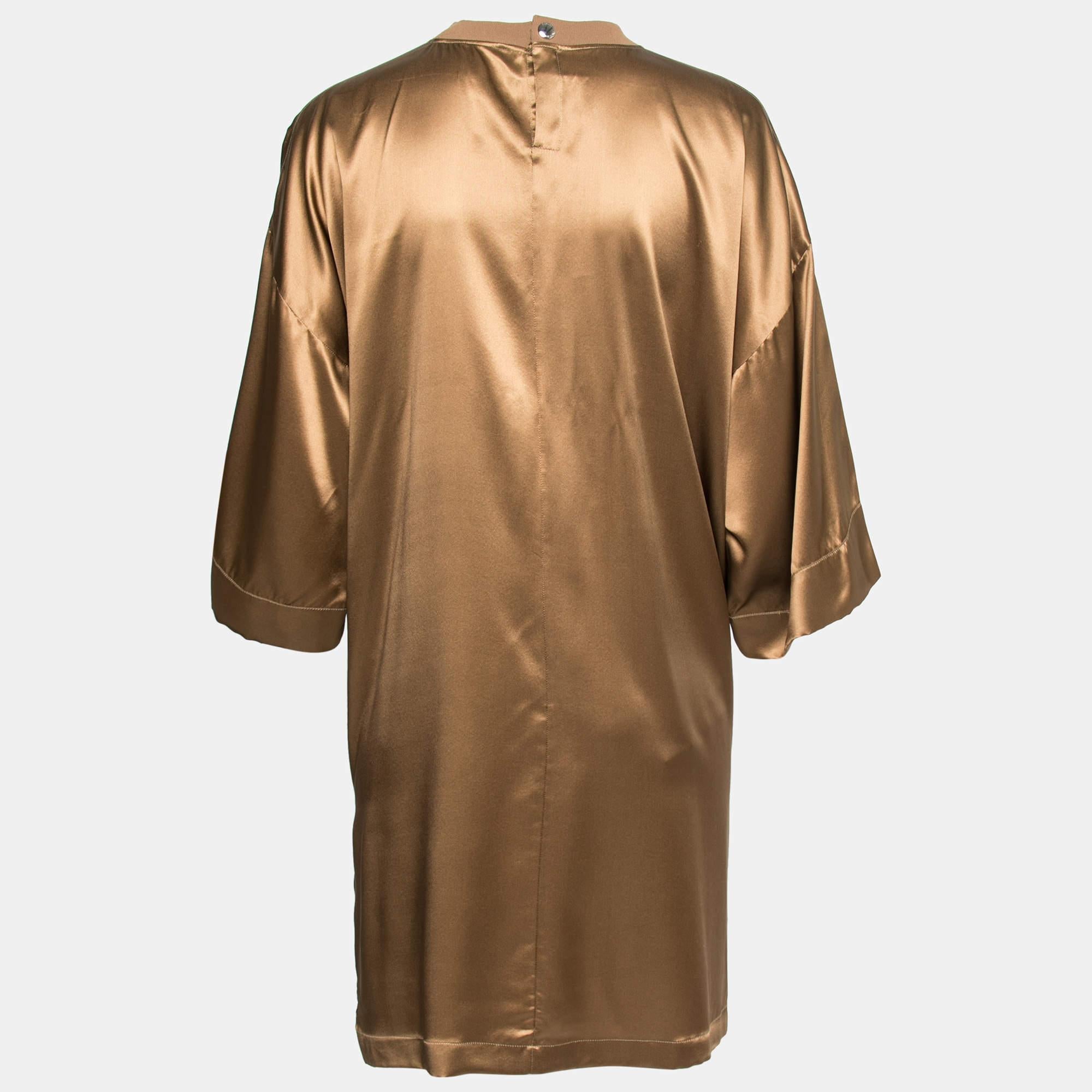 The smooth finished feel of this satin silk-tailored silhouette from Givenchy will lend a posh appeal to your attire and keep you comfortable. This oversized tunic flaunts a brown hue, a crew neck, and short sleeves. It is provided with a buttoned