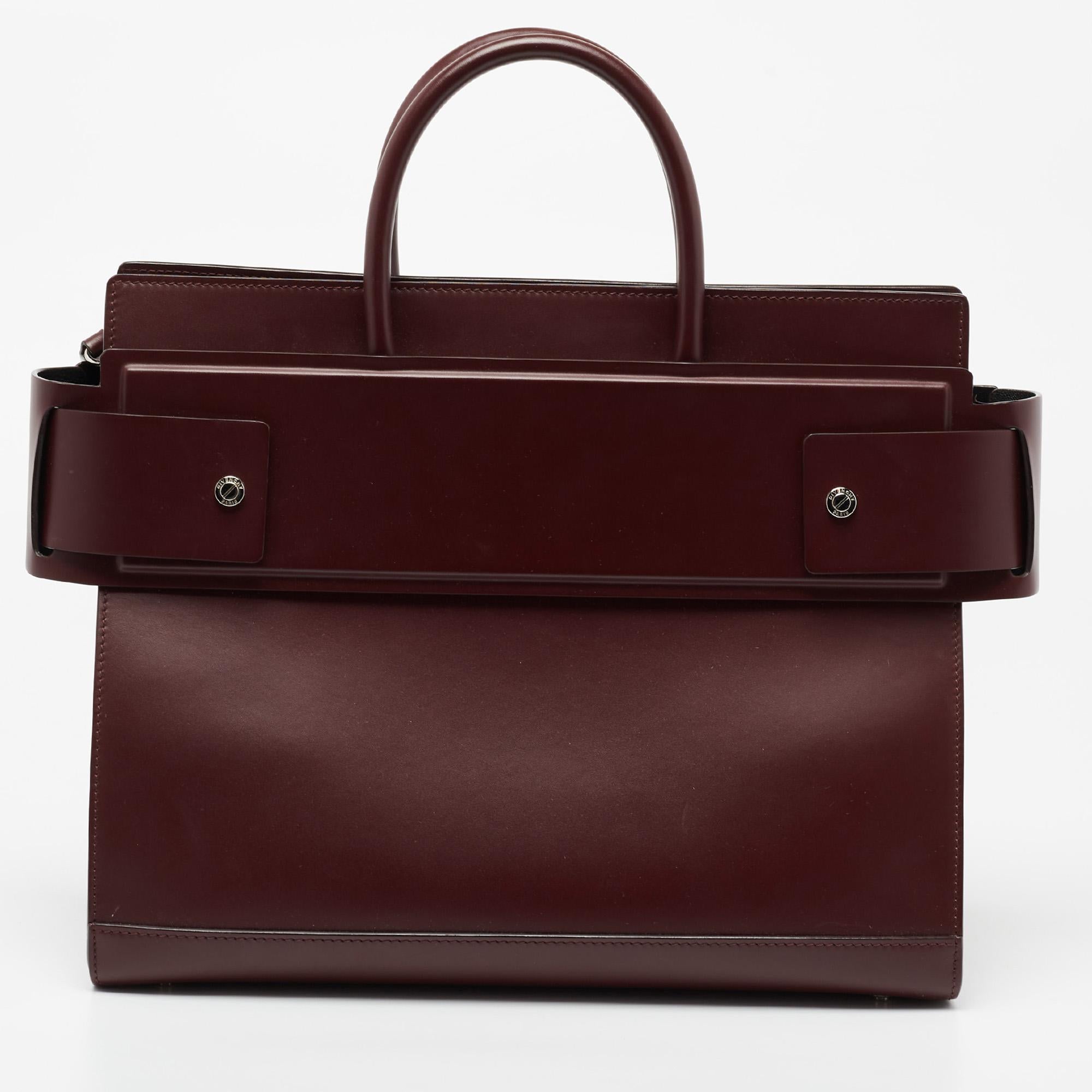 Givenchy is famed across the globe for its exquisite designs. From the brand's incredible collection comes this Horizon tote. Crafted from leather in a burgundy shade, the bag is aided by top handles and the label's logo stamped on the front. The