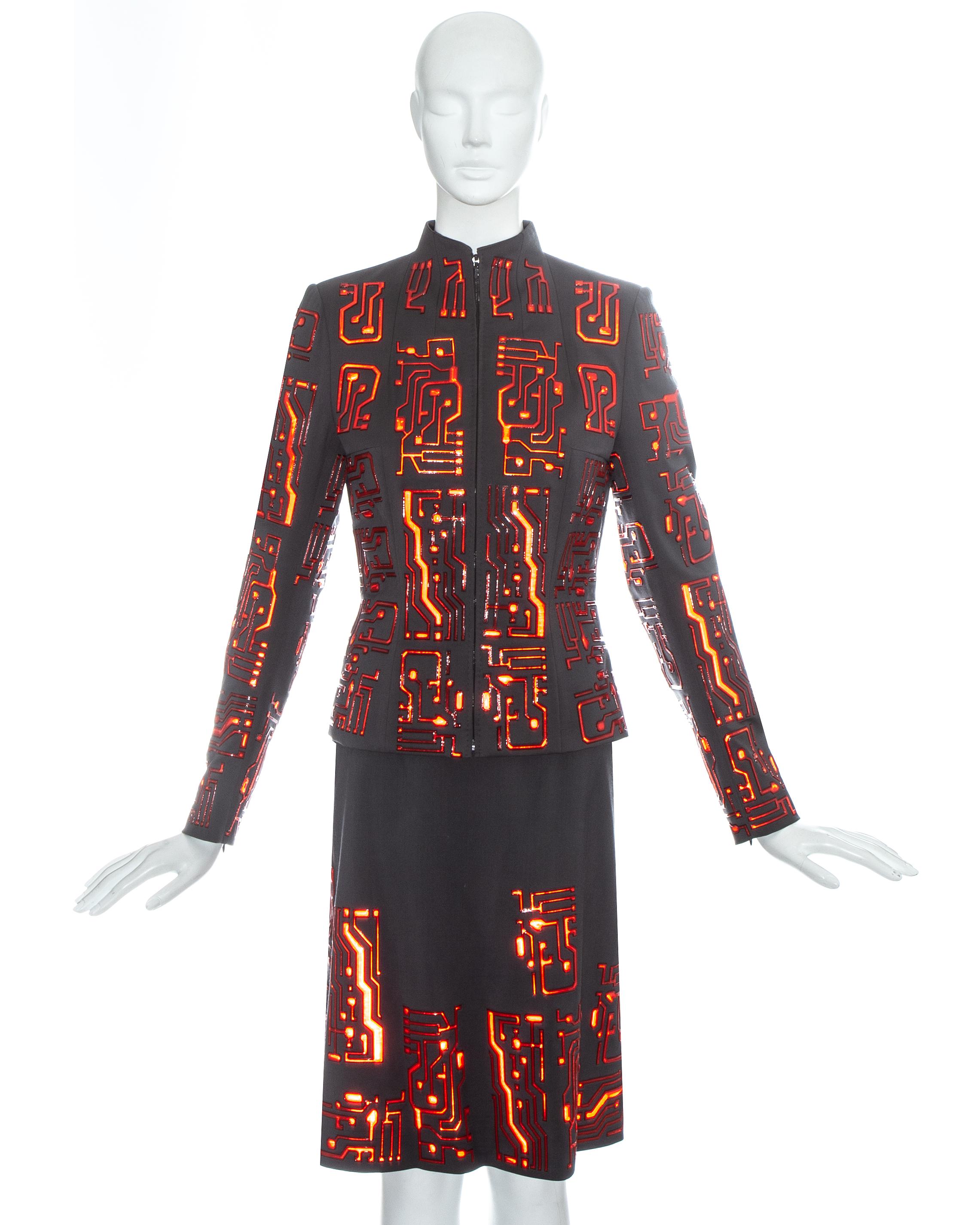 Givenchy by Alexander McQueen; grey wool skirt suit with red reflective plastic appliqués in the form of circuit boards. Zip fastening down centre front, fitted waist and silk lining. 

Fall-Winter 1999