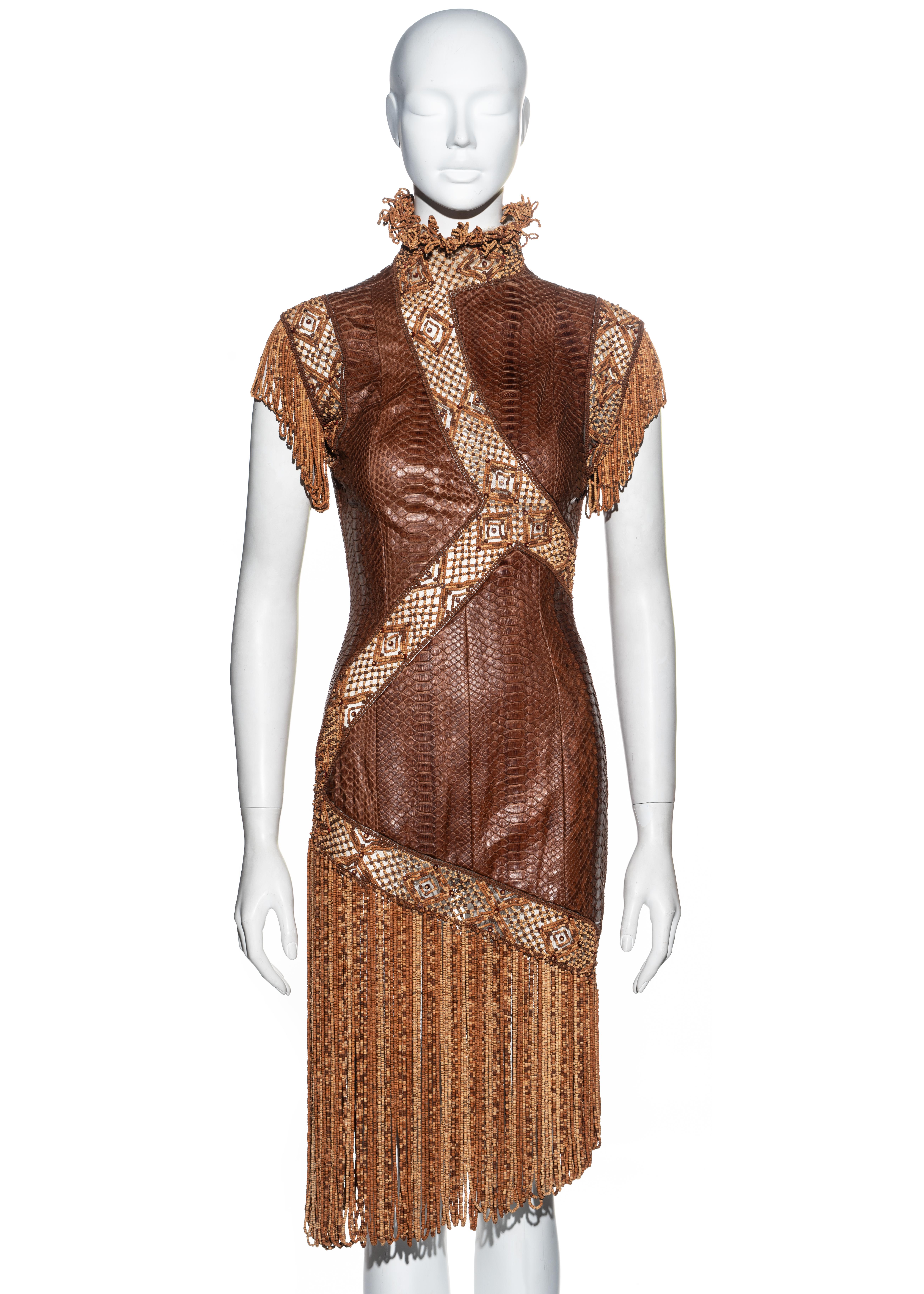 ▪ Givenchy Haute Couture brown snakeskin dress 
▪ Designed by Alexander McQueen
▪ Skintight fit 
▪ Vertical snakeskin panels with tulle bands 
▪ Embroidered with wood and cork beads 
▪ Beaded looped fringes on skirt, sleeves and collar
▪ Press