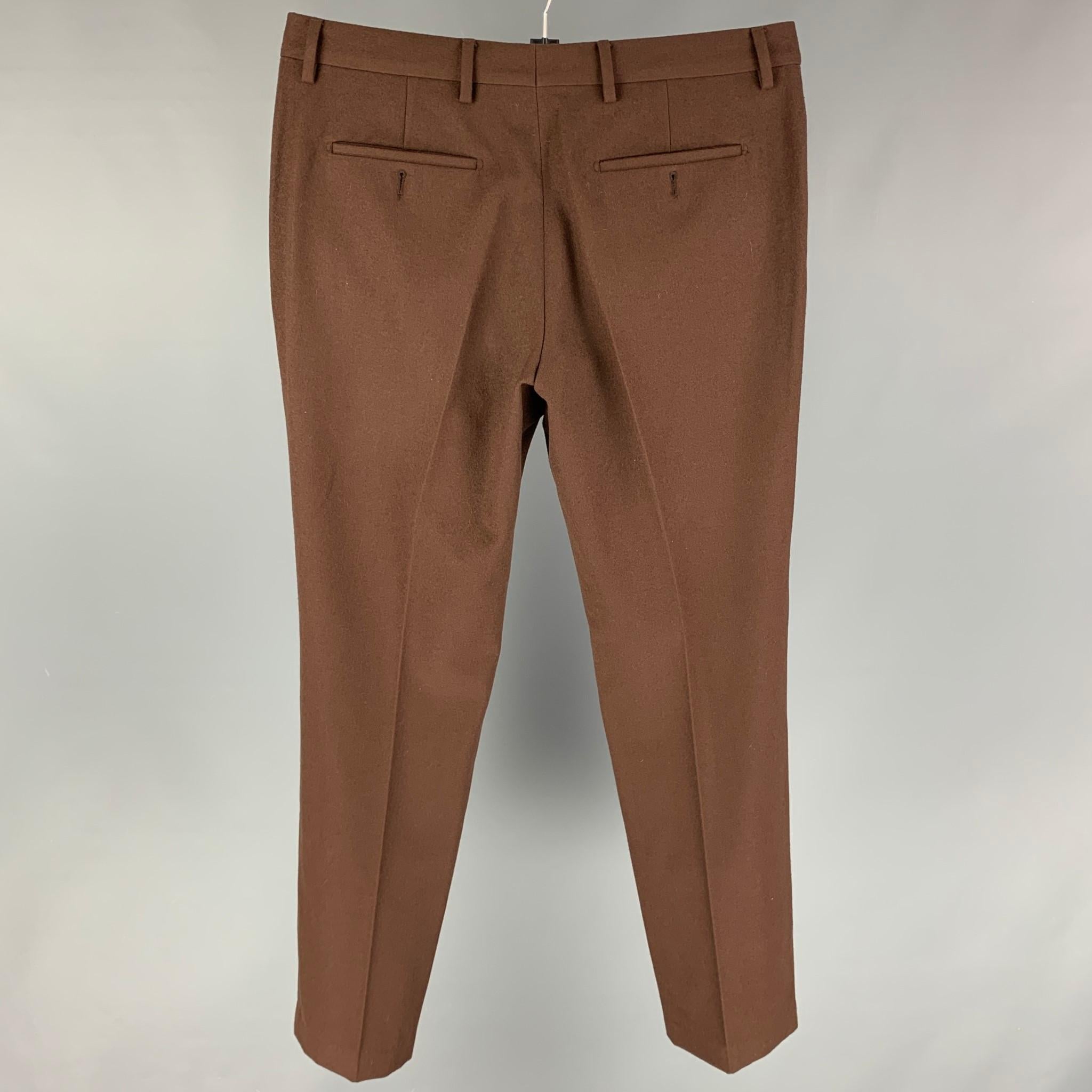 GIVENCHY By Ricardo Tisci 2012 dress pants comes in a brown wool featuring a flat front, straight leg, front tab, and a zip fly closure. Made in Italy.

Excellent Pre-Owned Condition.
Marked: 44

Measurements:

Waist: 34 in.
Rise: 10.5 in.
Inseam:
