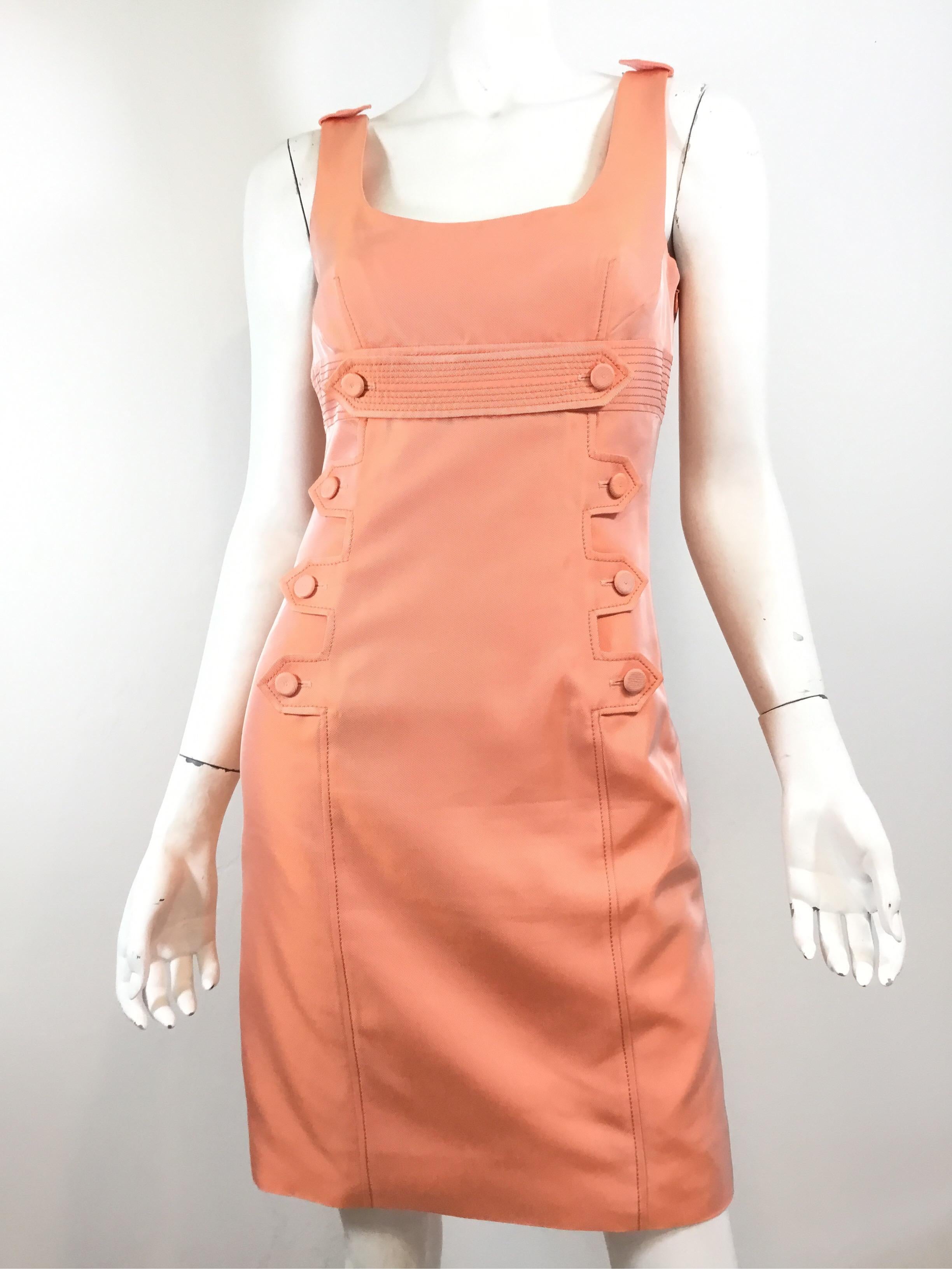 Givenchy Dress featured in a Coral/peach color with decorative buttons along the front. Dress has a side zipper fastening and full lining. Size 38, made in France. 

Bust 33”, waist 30”, hips 34”, length 32”