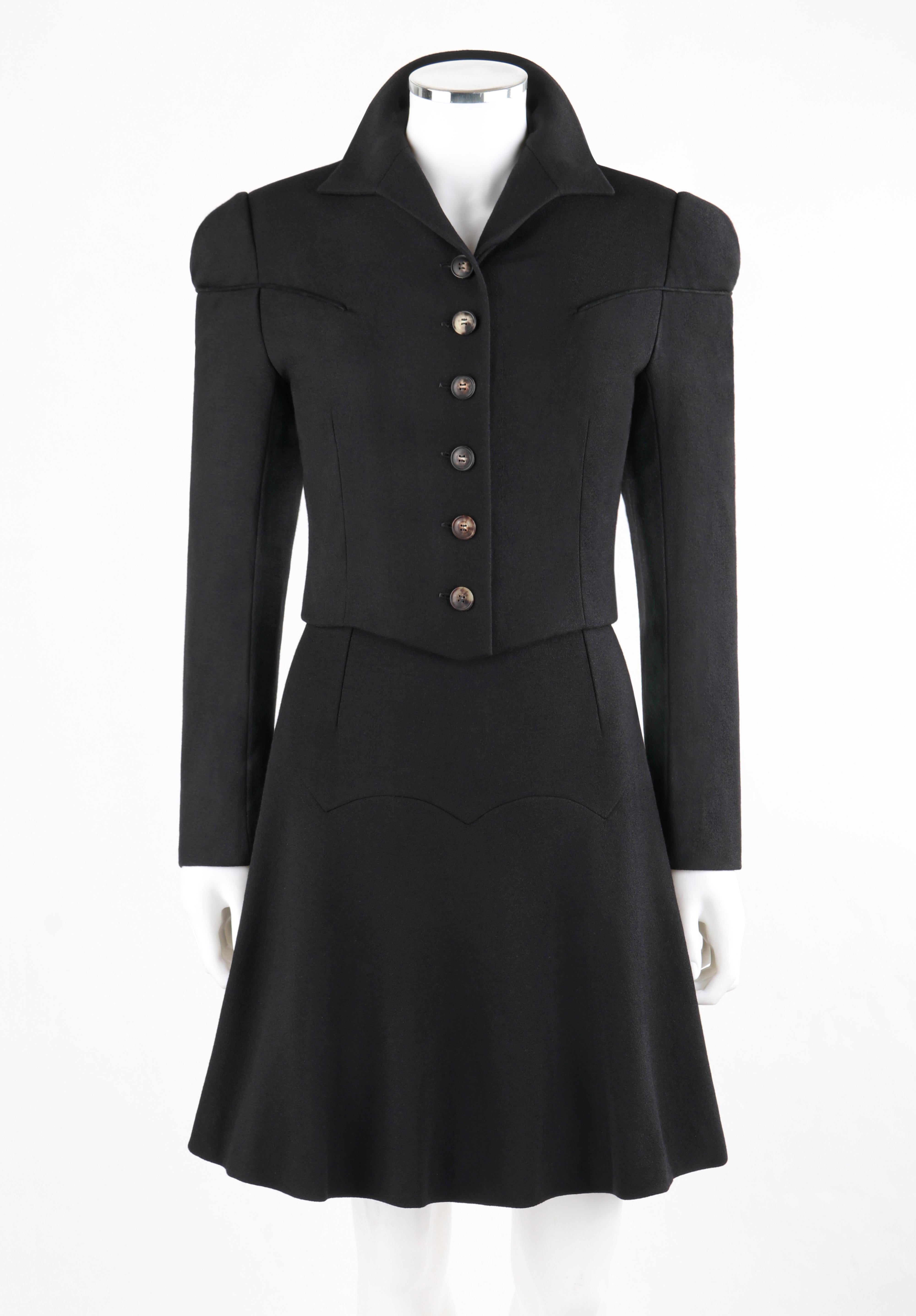Givenchy Couture by John Galliano two piece black wool skirt suit from the Autumn-Winter 1996 Collection. Long sleeved cropped jacket has piped detail. Buttons at front. Padded shoulders. Fully lined. A-line skirt has a yoke with scalloped edge