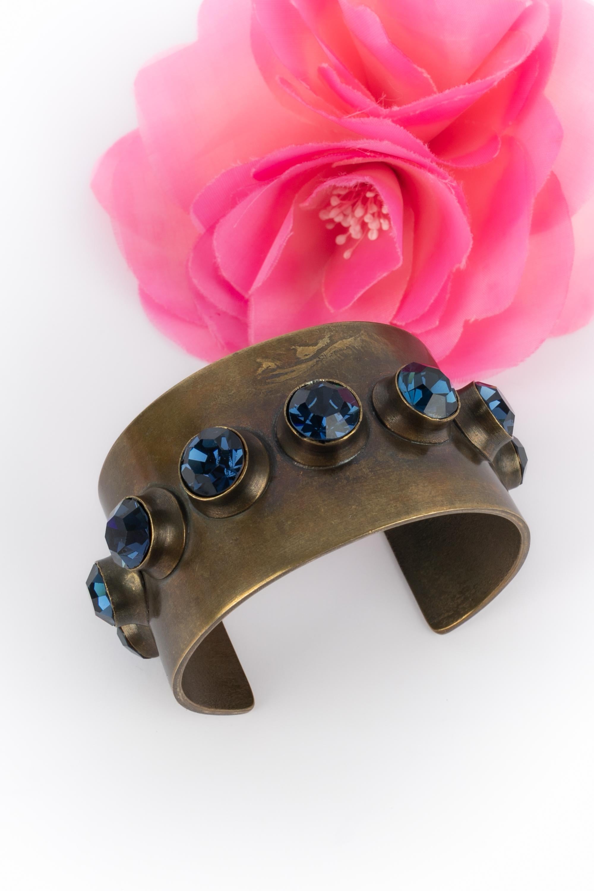 GIVENCHY - Coppery metal cuff bracelet ornamented with blue rhinestones. Not signed jewelry attributed to Givenchy.

Condition:
Very good condition

Dimensions:
Circumference: 15 cm - Opening: 3.8 cm - Width: 4 cm

SKU:BRA131