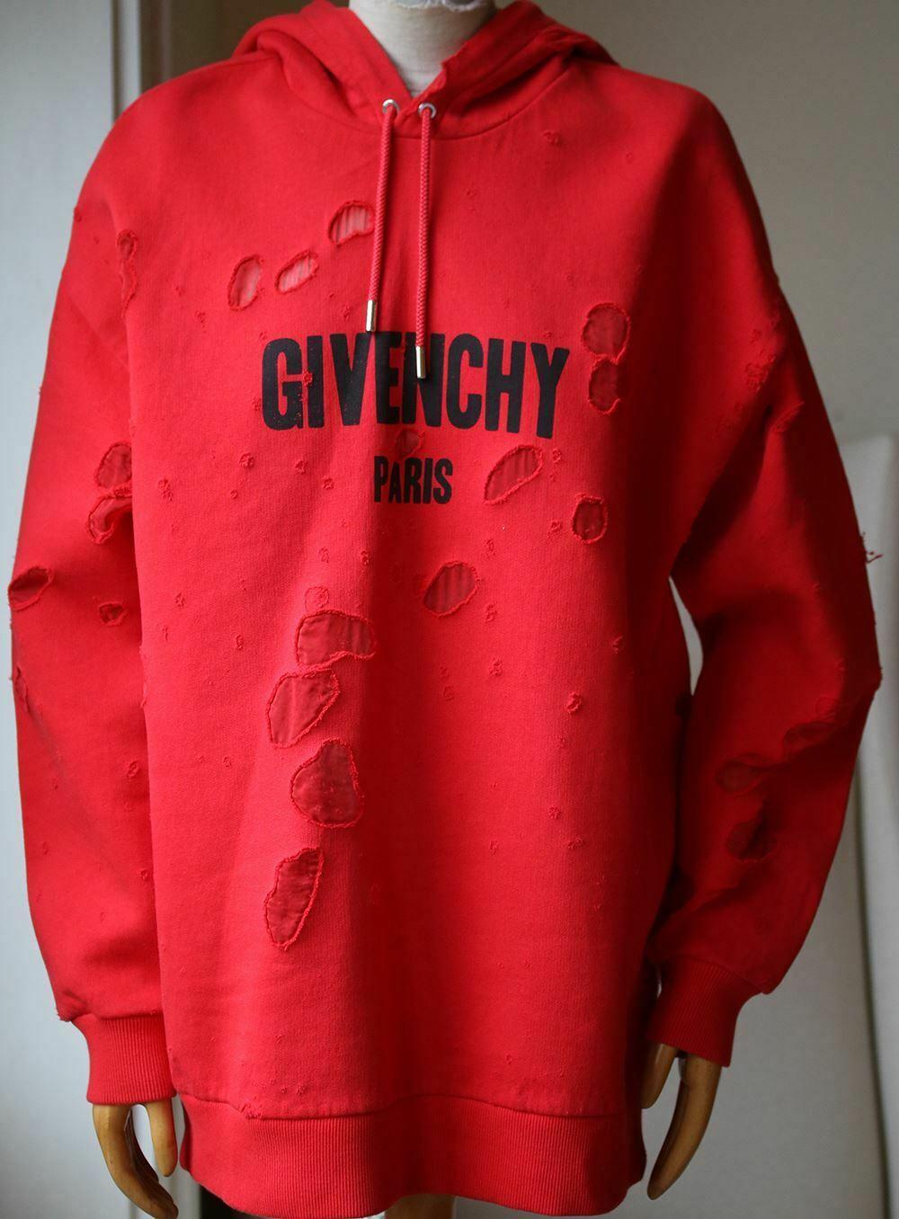 Riccardo Tisci's for Givenchy collection is divided into three categories, one being an urban lineup filled with oversized shapes and logos. This hooded sweatshirt is cut from red cotton-jersey and detailed with distressed cutouts backed in sheer