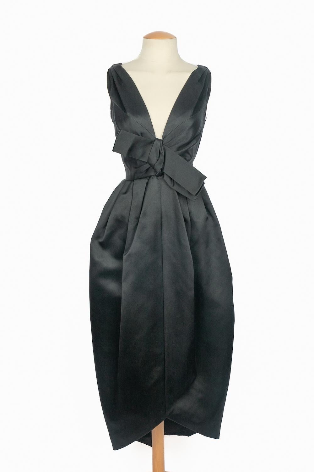 GIVENCHY - (Made in France) Schwarzes Kleid aus Seidensatin mit tiefem V-Ausschnitt, der mit einer Schleife verziert ist. Keine Größenangabe, es passt eine 34FR/36FR. Eine Haute Couture Collection um 1991, unter der künstlerischen Leitung von Hubert